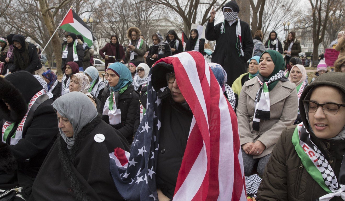 A Muslim woman drapes the US national flag over her head while joining other Muslims before prayer at President's Park beside Pennsylvania Avenue across the street from the White House. Photo: EPA-EFE
