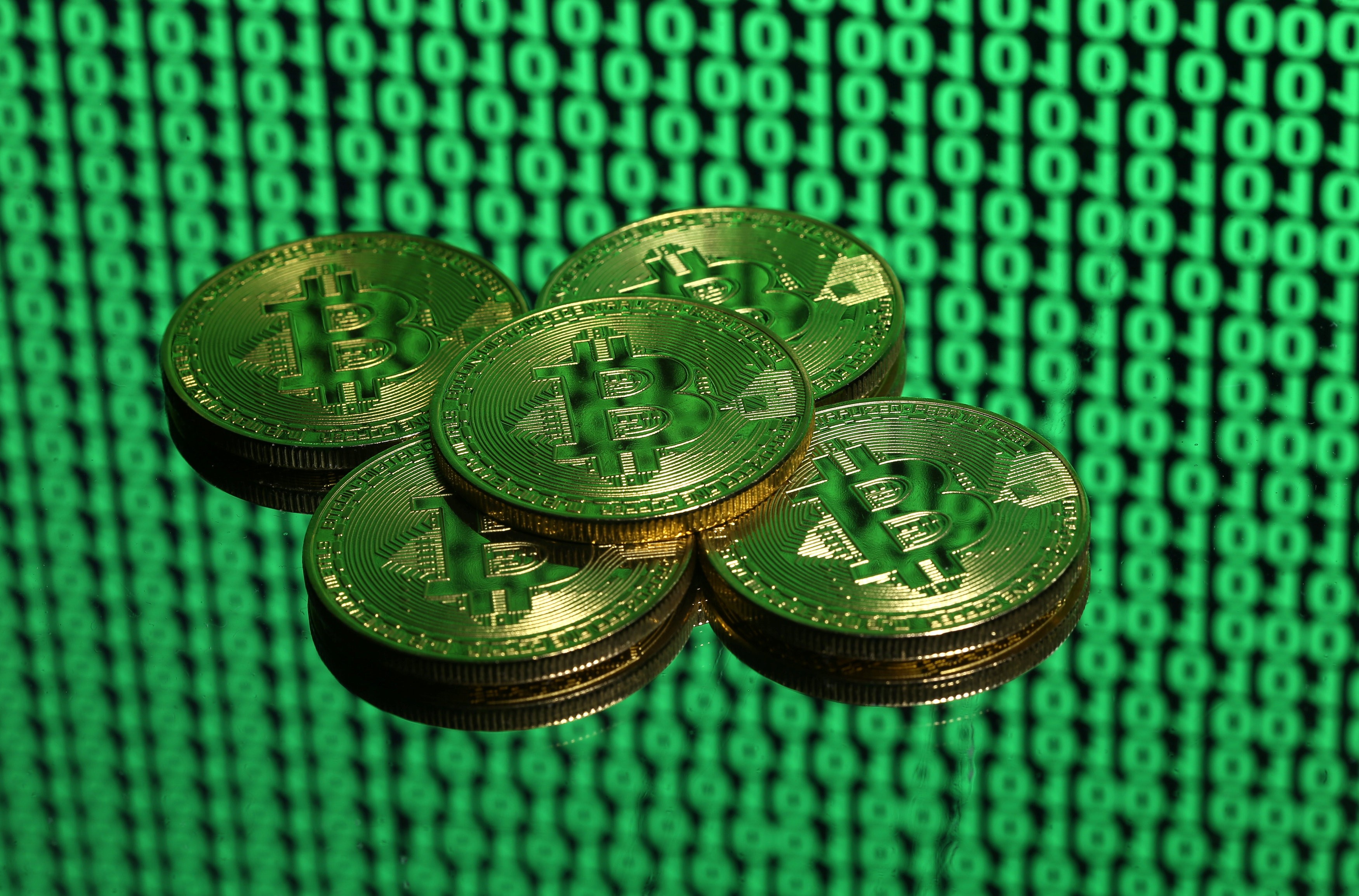 Tokens of the cryptocurrency bitcoin placed on a monitor displaying binary digits. Even if regulatory changes in the US do deflate the bitcoin bubble, they will not halt this financial revolution. Photo: Reuters