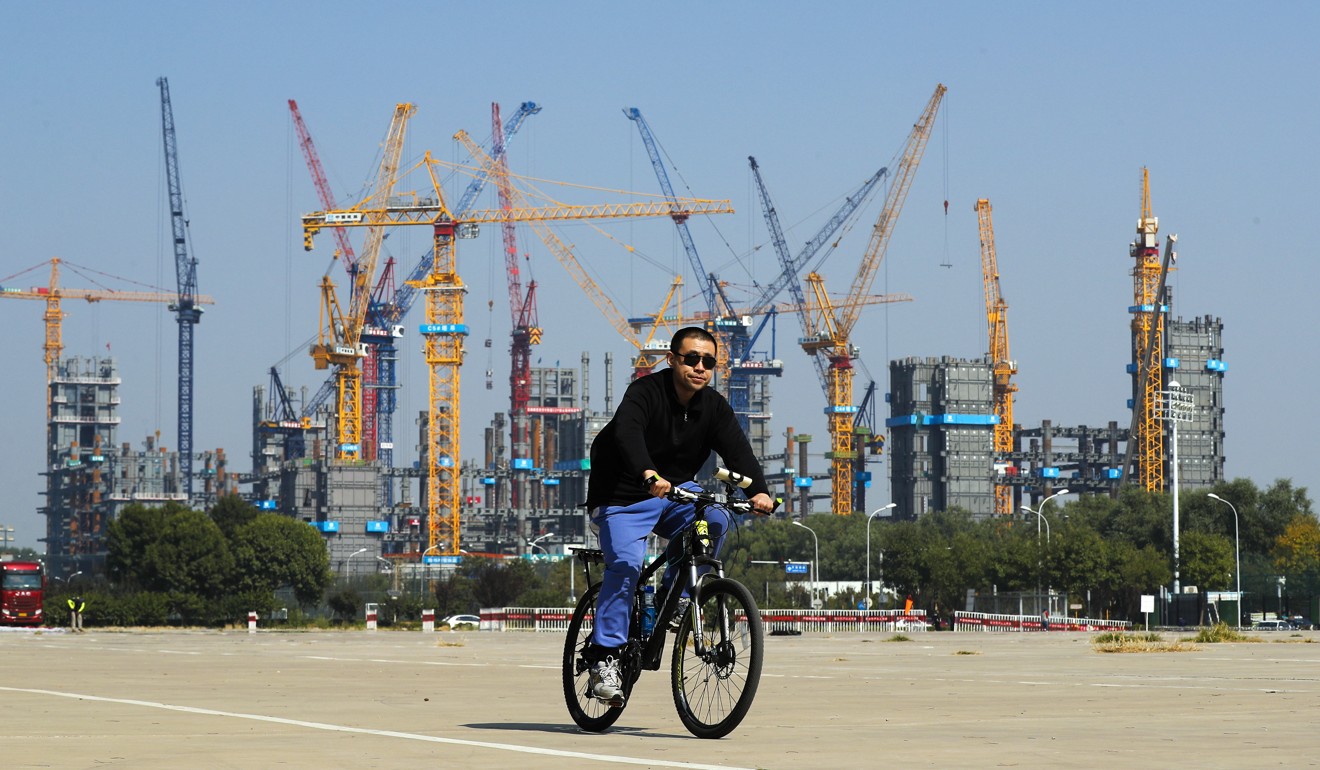 A man rides a bicycle past a construction in Beijing. A researcher at the Chinese Academy of Social Sciences said he expected China to rely more on “innate drivers” for economic growth in 2018, such as technology innovation. Photo: AP