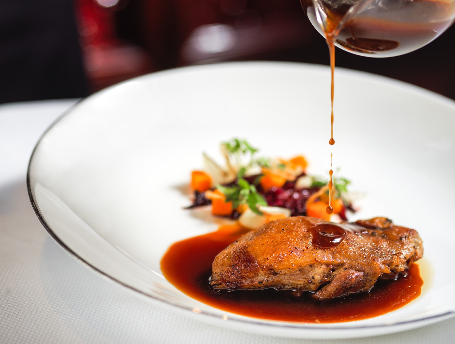 The slow-cooked Silver Hill Duck confit with braised radicchio, white onion puree, pickled pumpkin and orange jus.