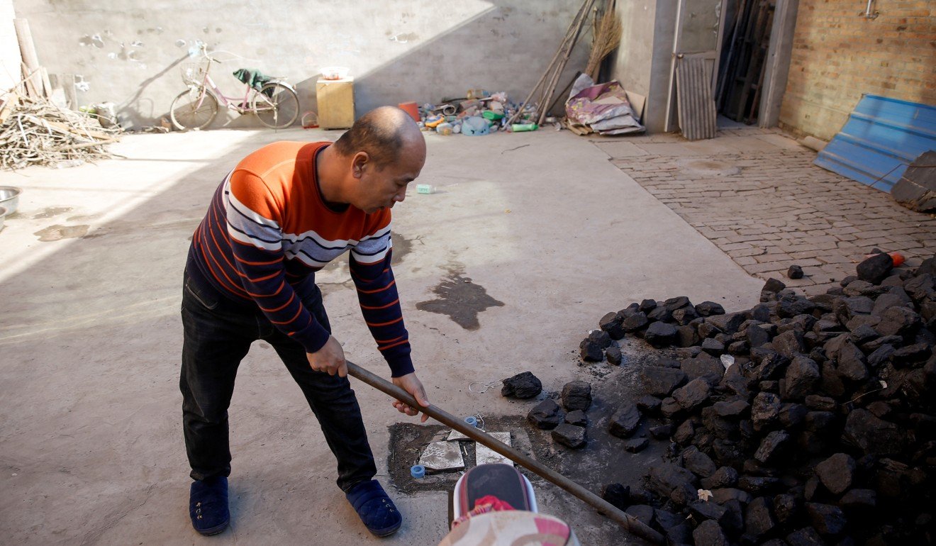 A man shovels coal he uses to heat his home in the village of Heqiaoxiang, Baoding, Hebei province, China. Photo: Reuters