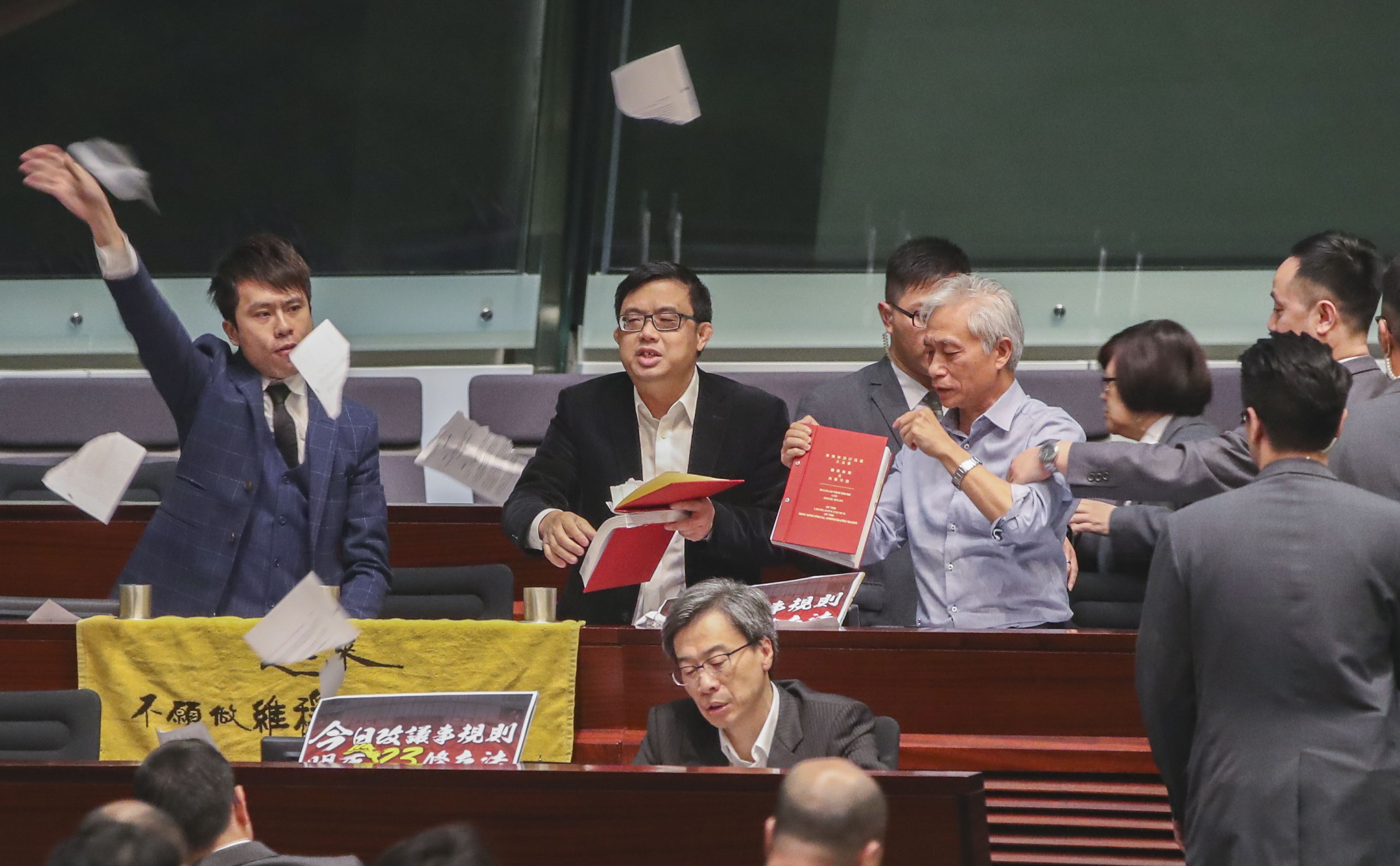 Lawmakers (from left) Roy Kwong Chun-yu and James To Kun-sun of the Democratic Party, and Leung Yiu-chung, tear up the Rules of Procedures and House Rules of the Legislative Council and throw the pages in the air, during a debate on the proposed amendment to the rules of Legco meetings, on December 15. Photo: Edward Wong