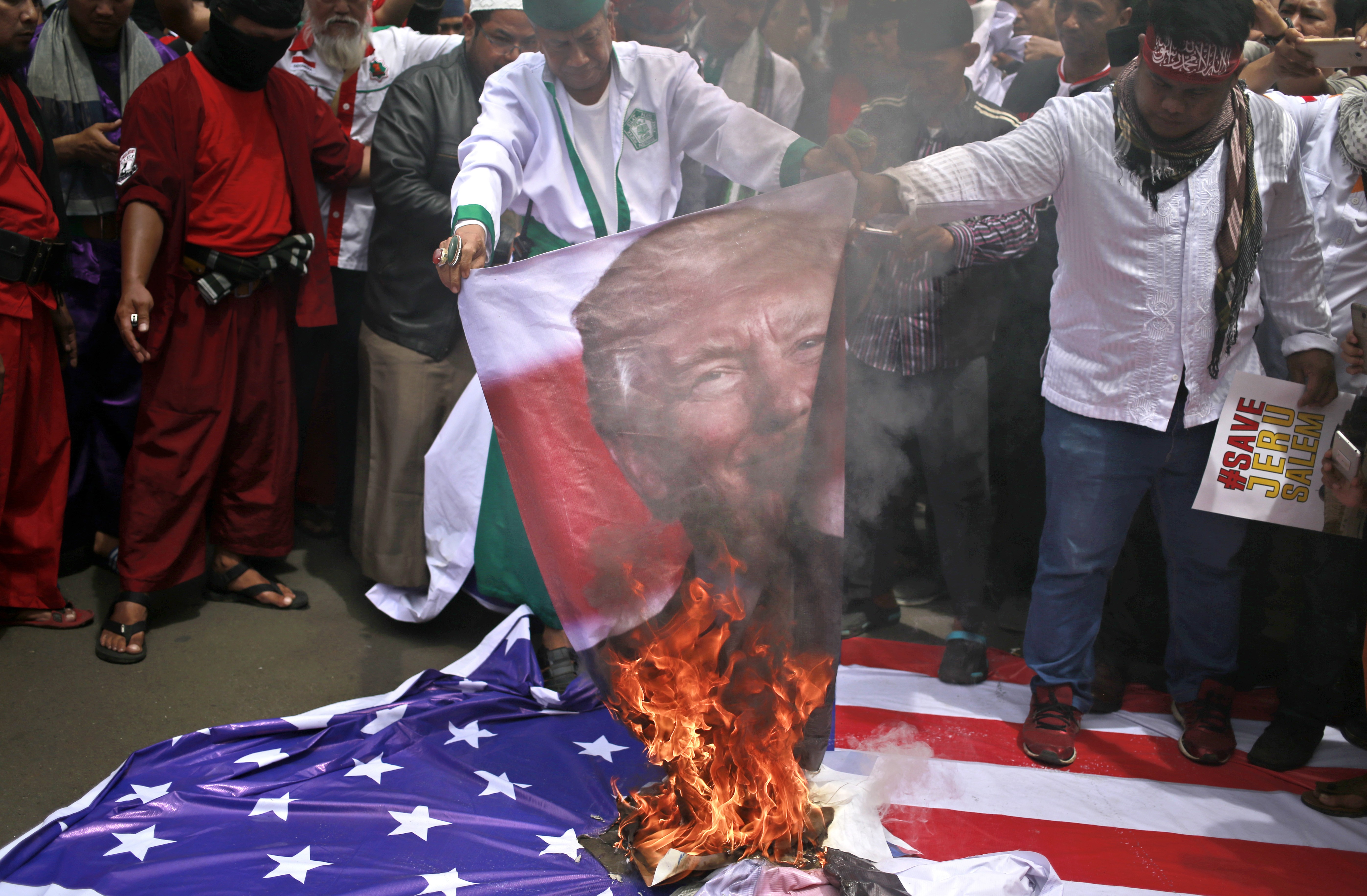 Protesters in Jakarta, Indonesia, burn a poster of US President Donald Trump during a rally outside US Embassy in the city, on December 11, to denounce Trump's decision to recognise Jerusalem as Israel's capital. Photo: AP