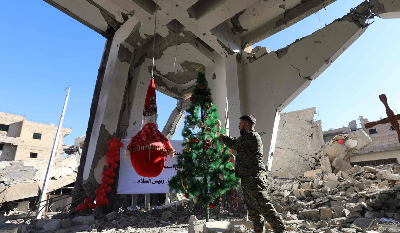 A member of the Syrian Arab-Kurdish arranges a tree ahead of a Christmas celebration at the Armenian Catholic Church of the Martyrs. Such festivities would have been impossible had coalition troops not swept IS out of the city. Photo: AFP