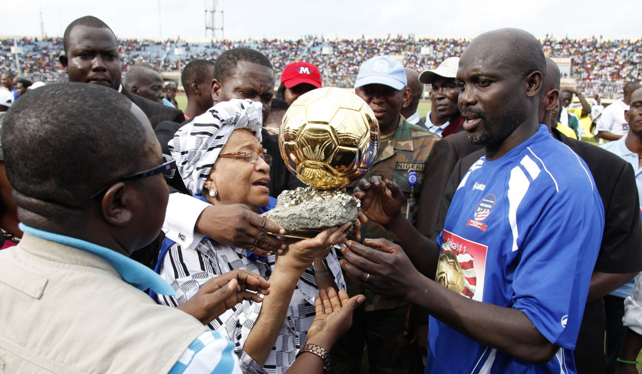 File photo of former football player and Liberia’s then main opposition leader George Weah presented his Ballon D'or trophy to Liberia’s President Ellen Johnson Sirleaf in 2013. Photo: AFP