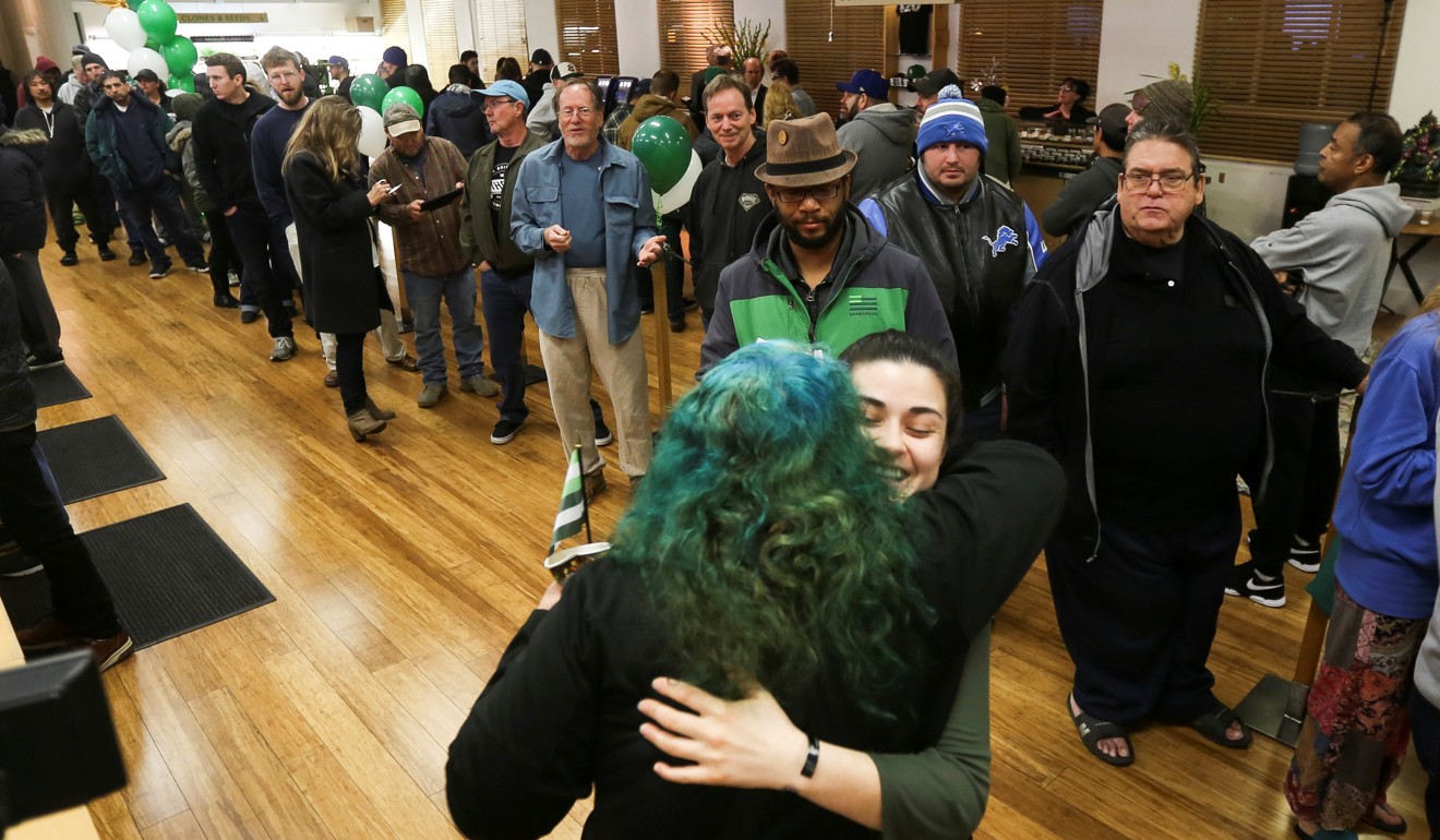 An employee hugs a customer as others wait in line at Harborside, one of California's largest and oldest dispensaries of medical marijuana, on the first day of legalised recreational marijuana. Harborside is located in Oakland, California. Photo: Reuters