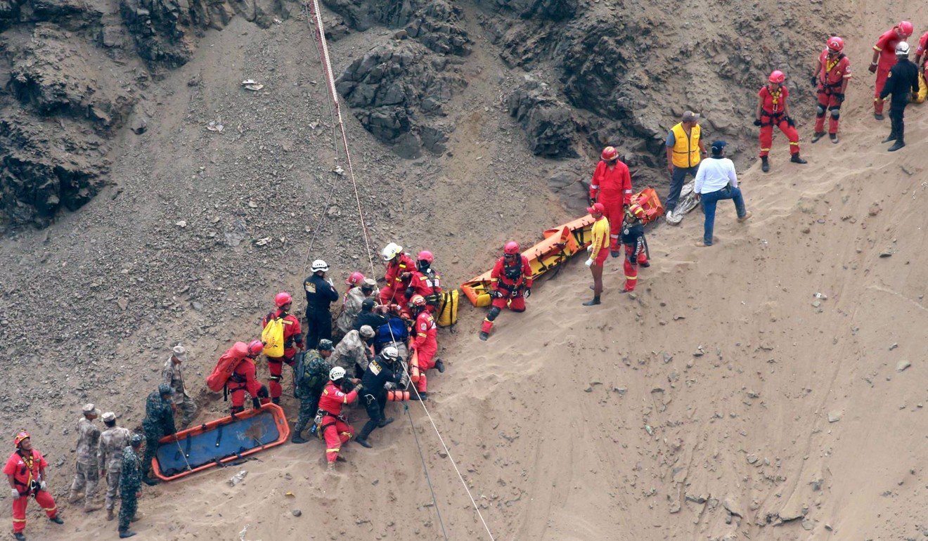 Rescuers surround an injured man on a stretcher who was lifted up from the site of Tuesday’s bus crash at the bottom of a cliff. Photo: AP