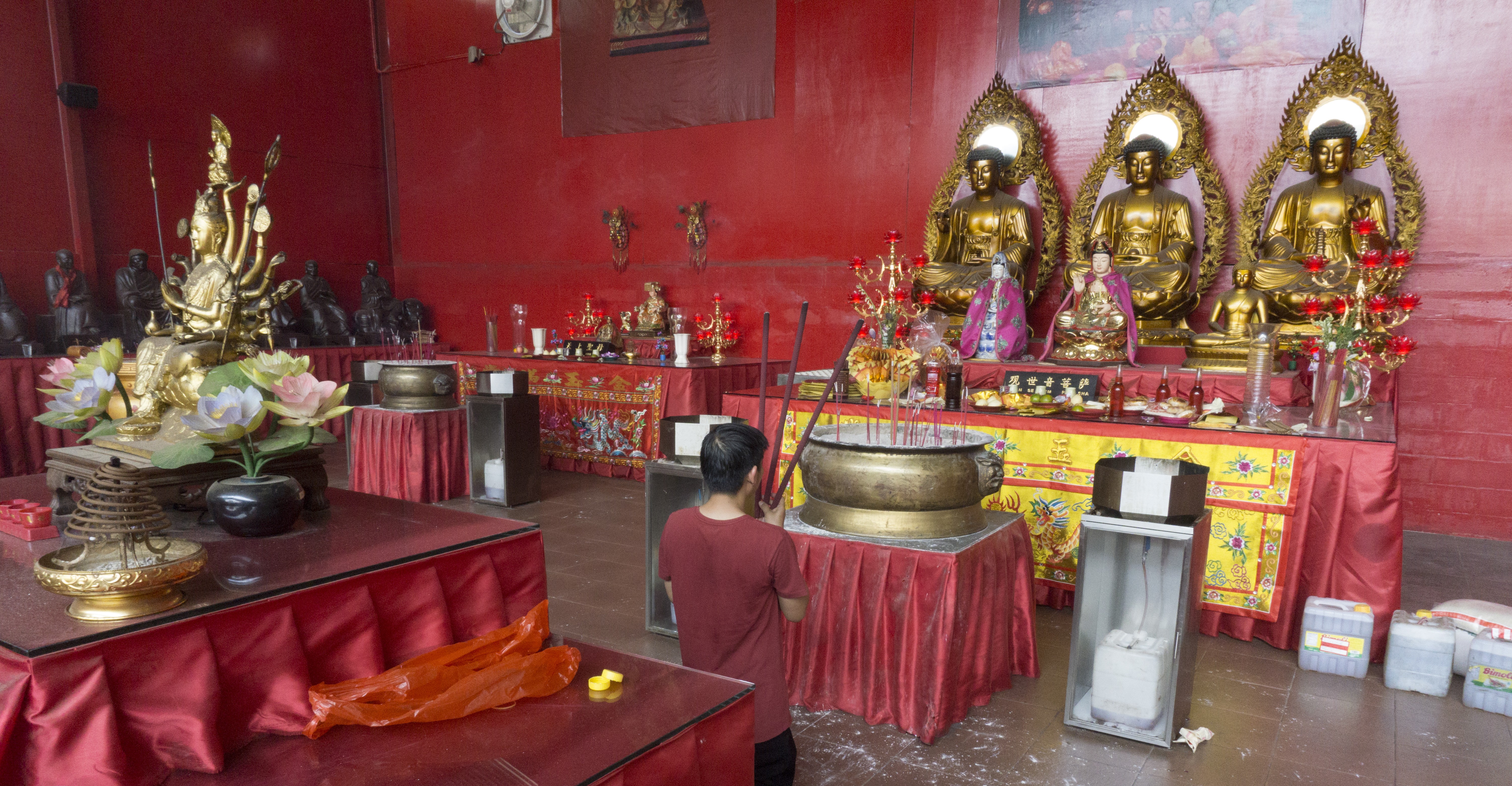 A worshipper kneels before an altar inside a temporary prayer hall, built after the 2015 fire, at the Dharma Bhakti temple in Jakarta, Indonesia. Photo: Nivell Radya