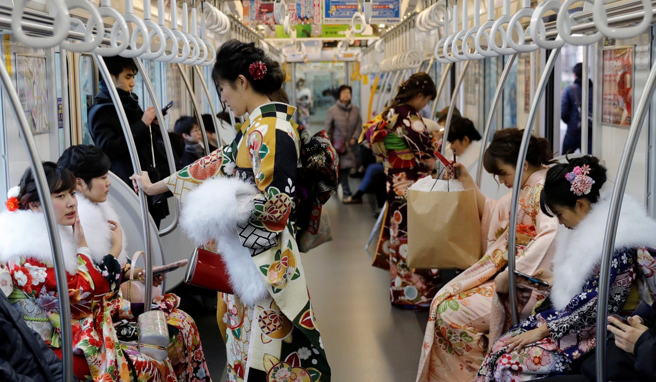 Japanese women wearing kimonos ride a train after attending their Coming of Age Day celebration in Tokyo. Photo: Reuters