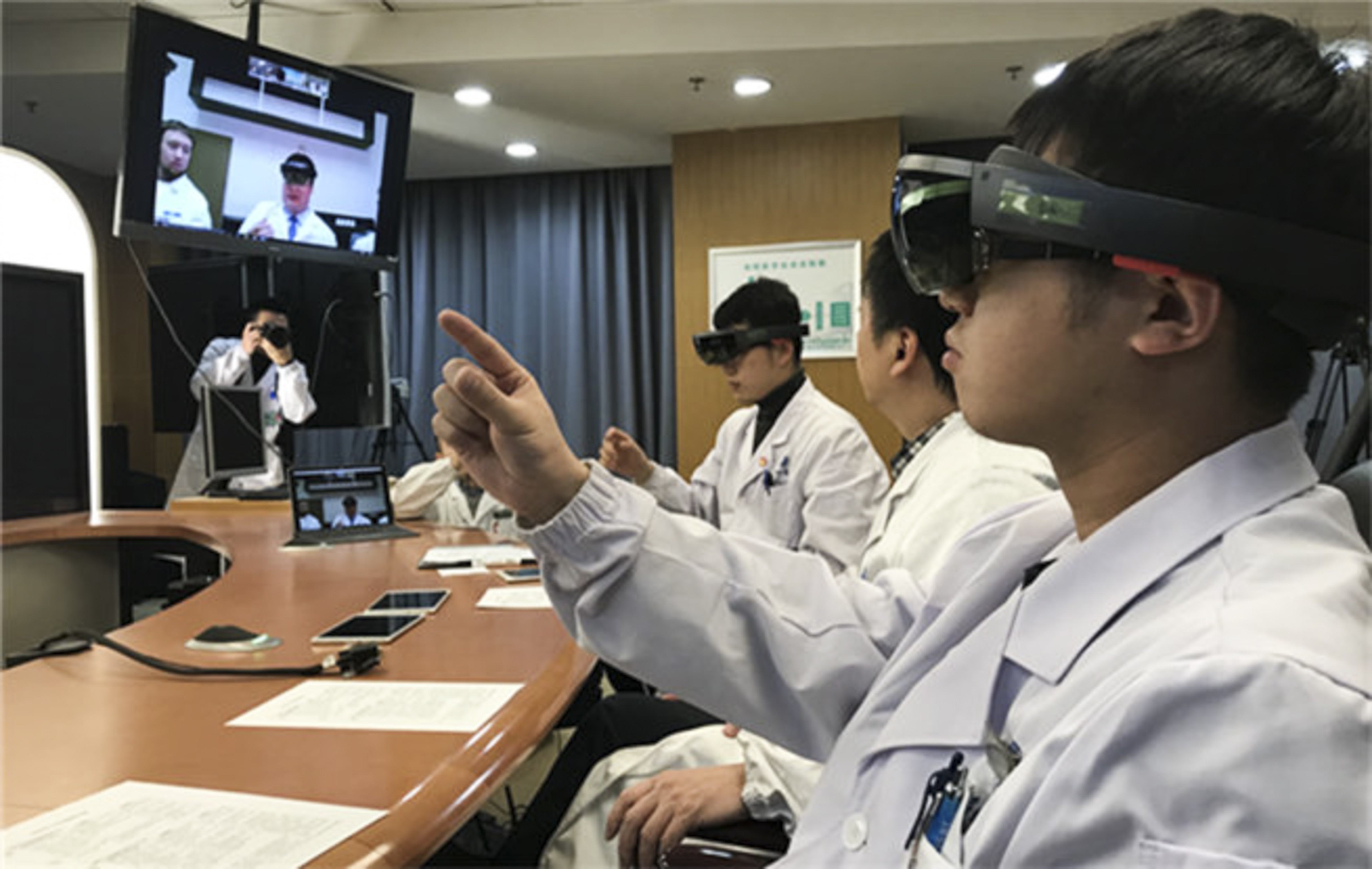 Medical staff in the two hospitals communicate through their 3D imaging headsets. Photo: New.qq.com