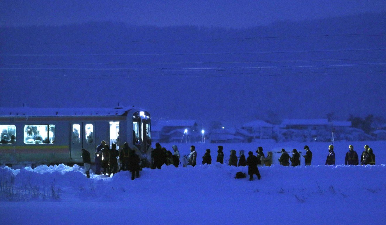 People wait to meet their families and relatives who are trapped on the train that was stranded by thick snow. Photo: Kyodo