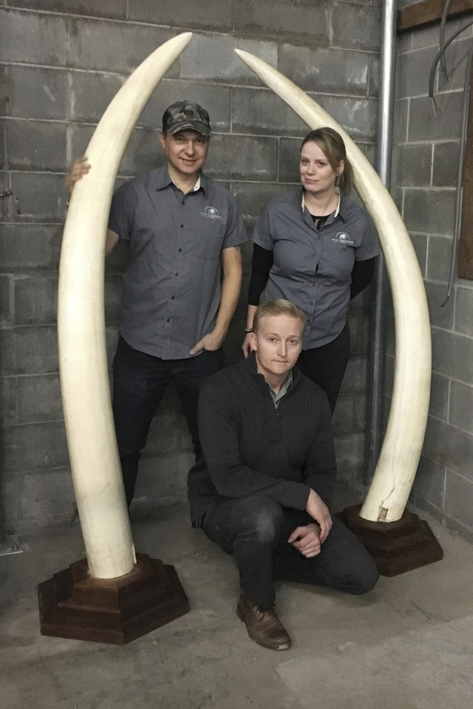 John Steward (left) and Wendy Hapgood (right), directors of the Wild Tomorrow Fund, pose with Lt. Jesse Paluch of the New York State Department of Environmental Conservation and a pair of elephant tusks at a New York State Department of Environmental Conservation warehouse in Albany, New York. Photo: AP