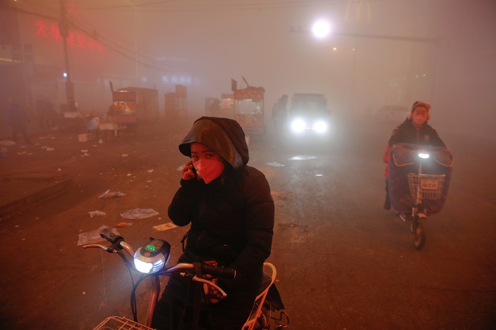 People make their way through heavy smog on an extremely polluted day in Shengfang, Hebei province. Photo: Reuters