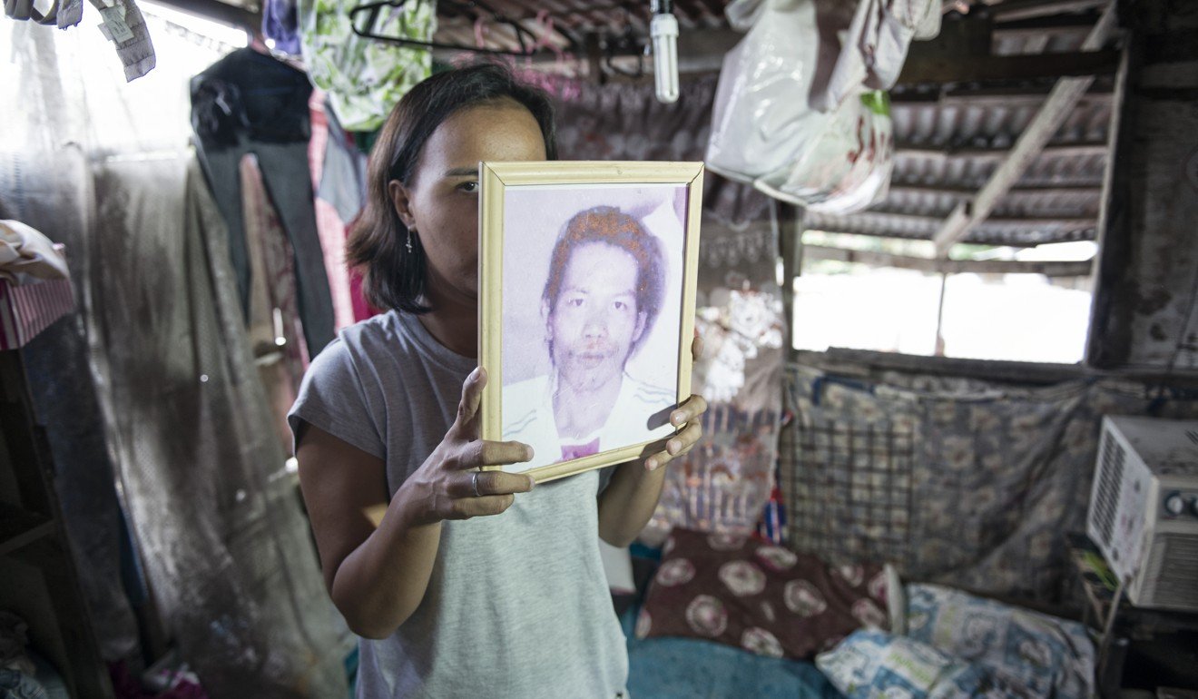 Katrina Polo holds a portrait of her husband, Cherwen, in the home where he was gunned down along with three friends as they celebrated his 38th birthday, on the night of August 14, 2016. 