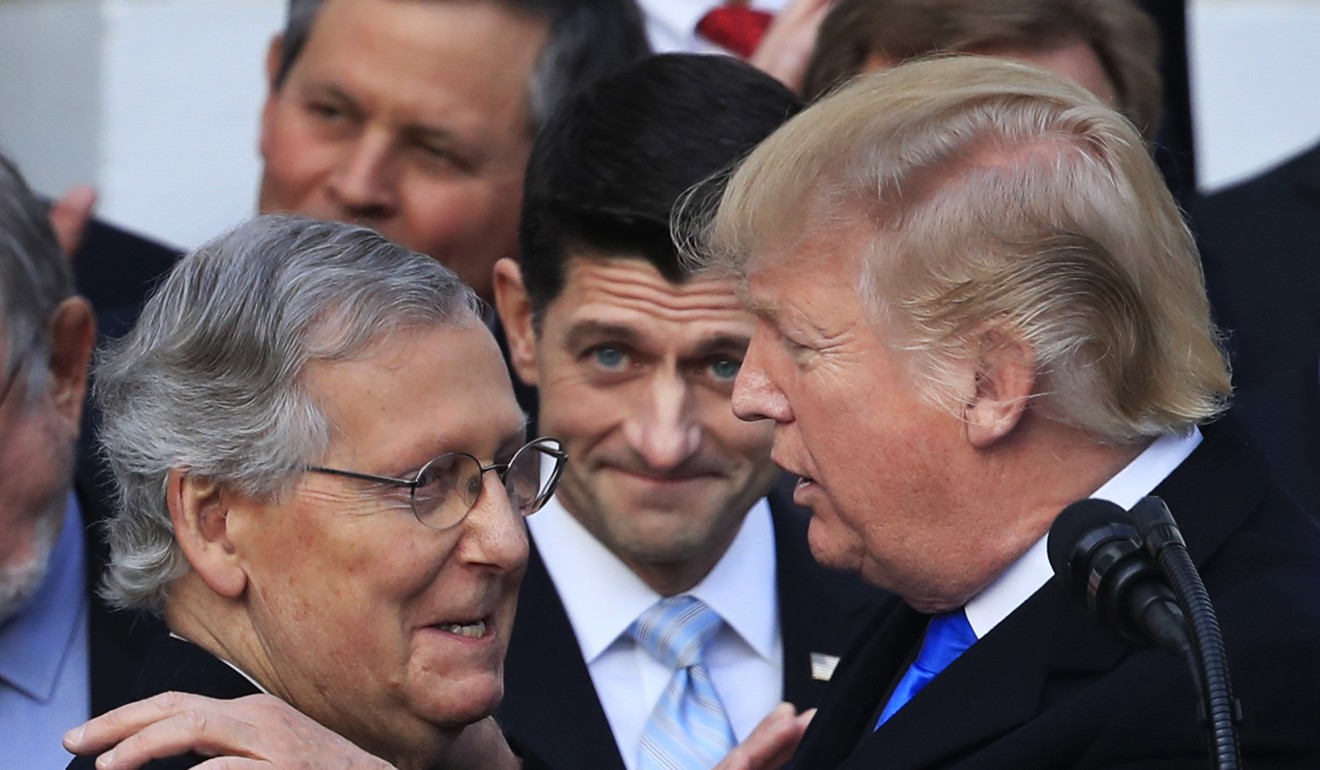 Trump congratulates Senate Majority Leader Mitch McConnell on the final passage of tax overhaul legislation by Congress in December, 2017. Photo: AP