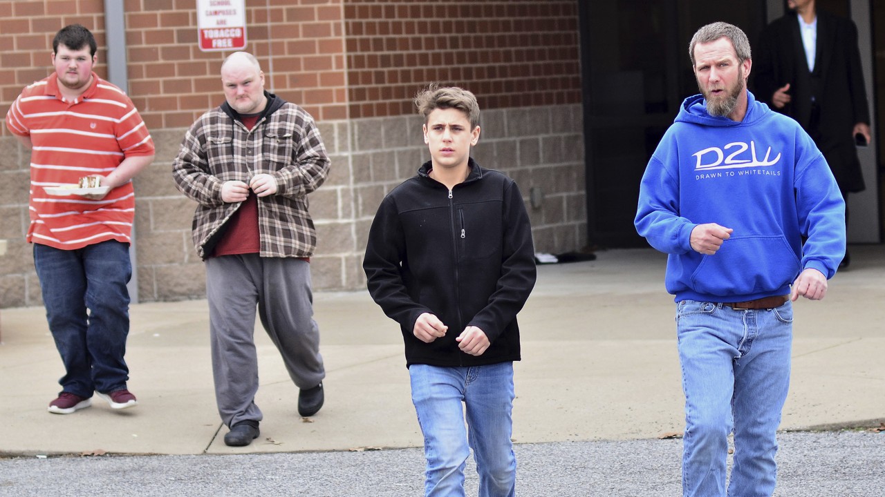 Family members escort their children out of Marshal North Middle School near Palma, Kentucky on January 23, 2018, after being transported from Marshal High School. The students of the high school were transported to the middle school to be picked up by family members after a shooting. Photo: AP