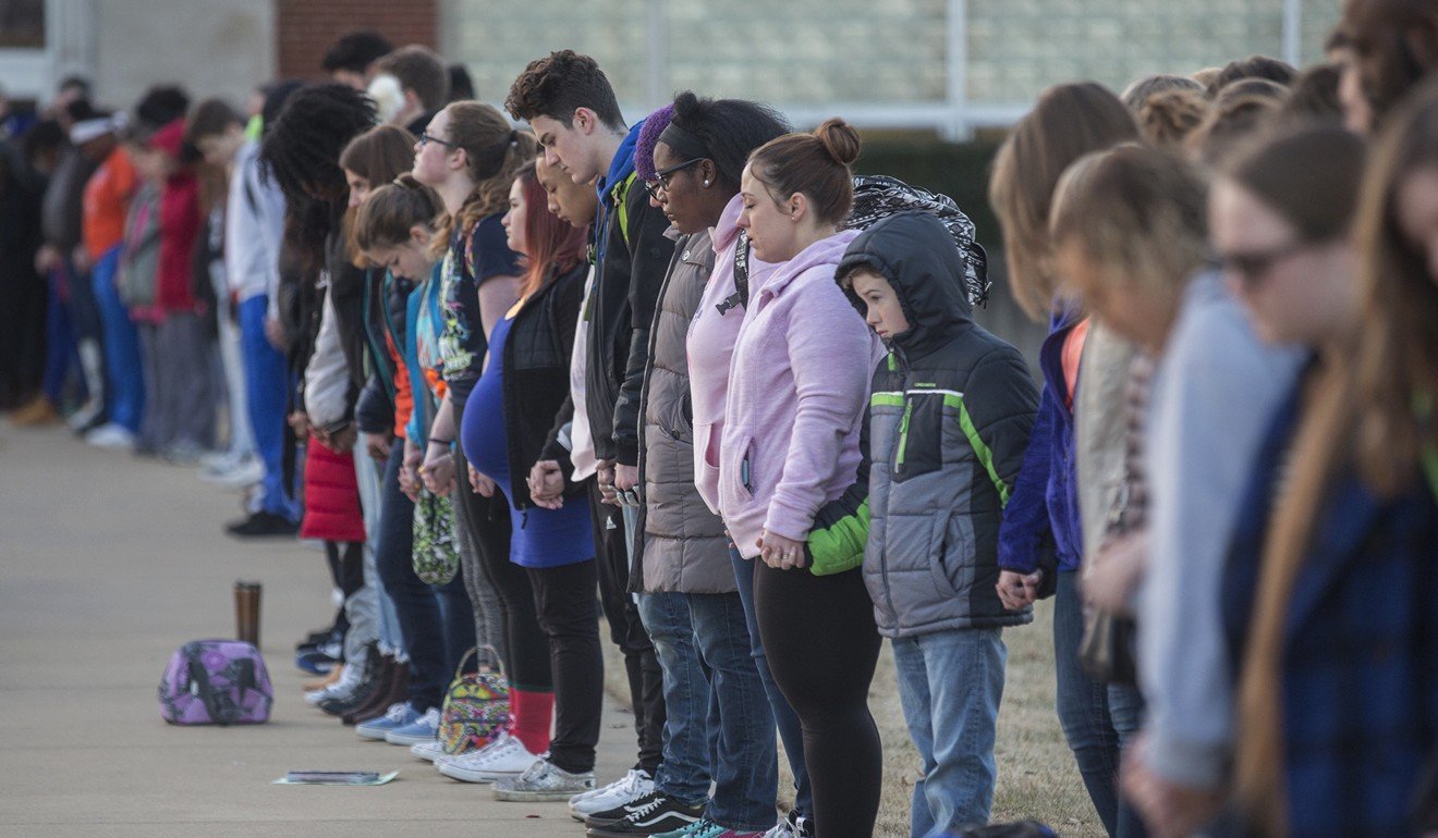 Students and community members hold hands in prayer before classes at Paducah Tilghman High School in Paducah, Kentucky, on January 24, 2018. The gathering was held for the victims of the Marshall County High School shooting on Tuesday. Photo: The Paducah Sun via AP