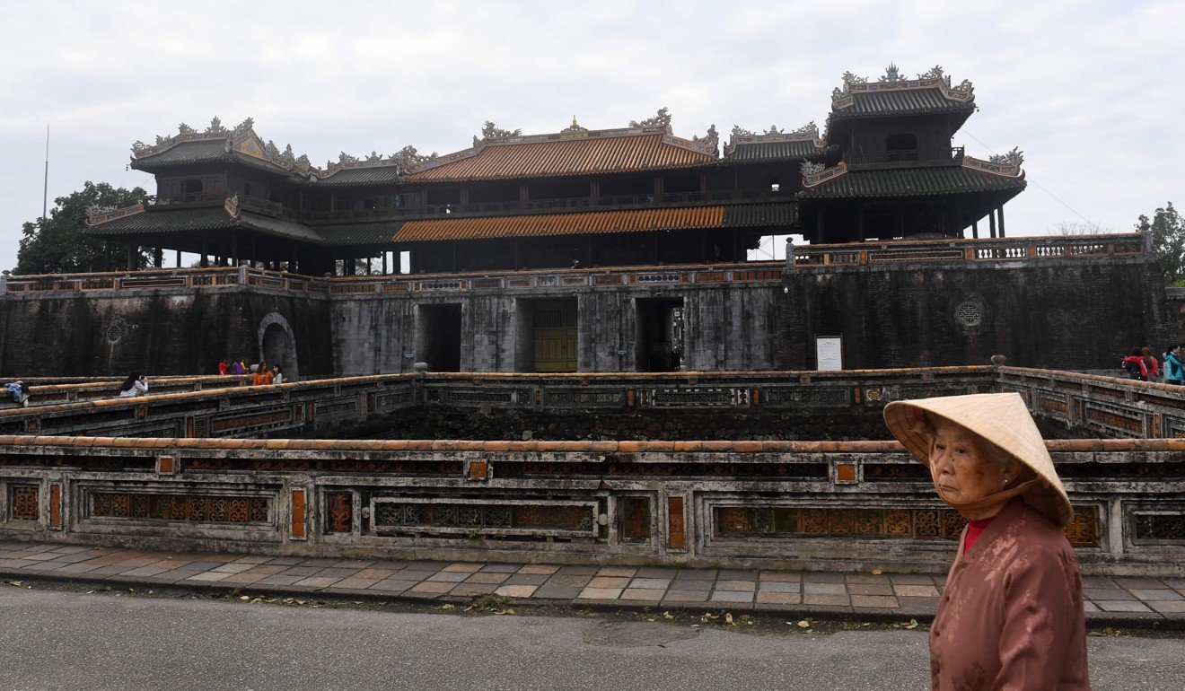 An elderly woman walks in front of the former imperial citadel where fierce fighting took place during the 1968 Tet Offensive in Hue. Photo: AFP