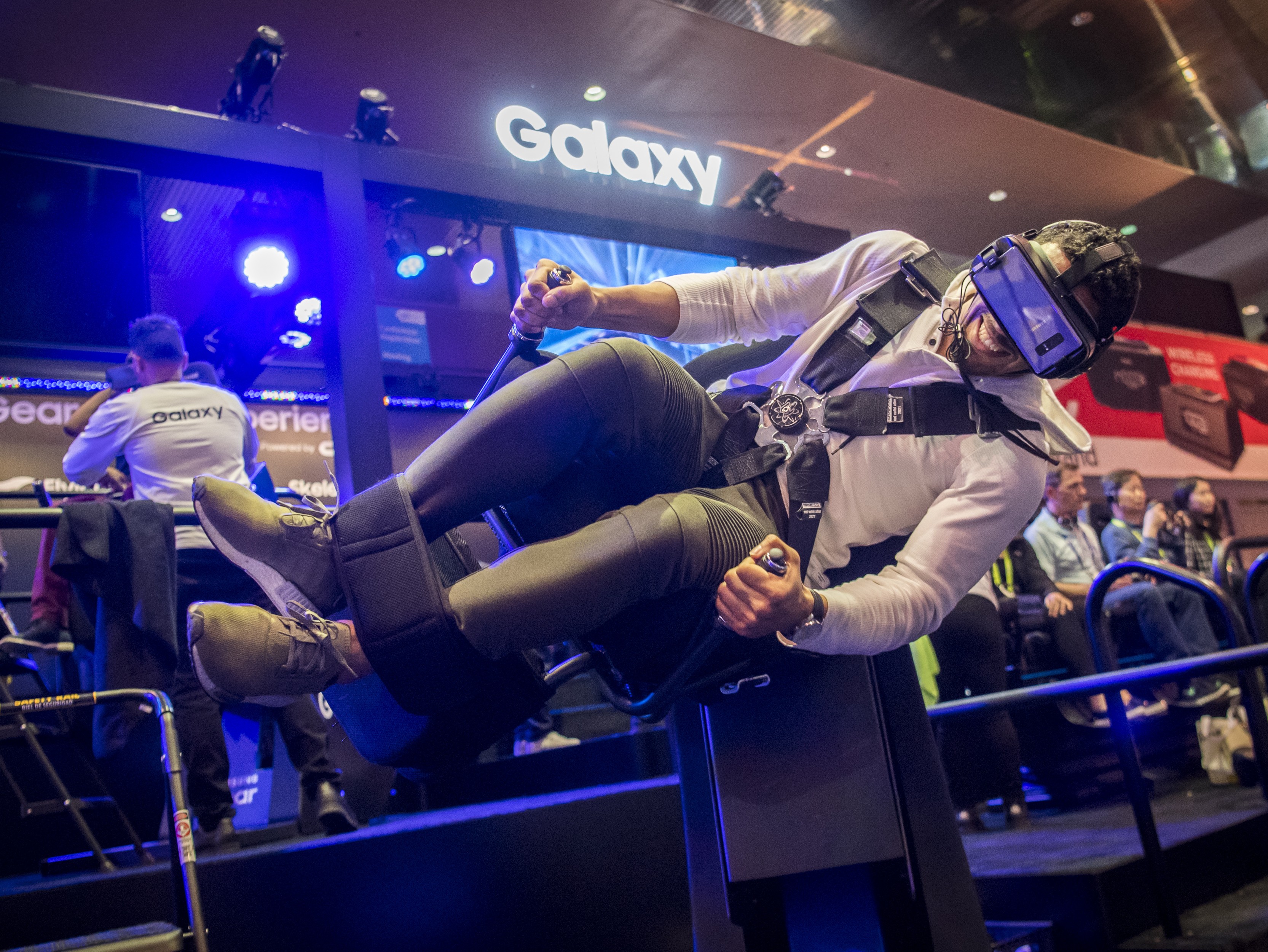 An attendee wearing a Samsung virtual reality headset rides the Flying Dino simulator during the 2018 Consumer Electronics Show in Las Vegas on January 10. Electric and driverless cars were a major part of this year's CES, as makers of hi-tech cameras, batteries and AI software vie to climb into automakers' dashboards. Photo: Bloomberg