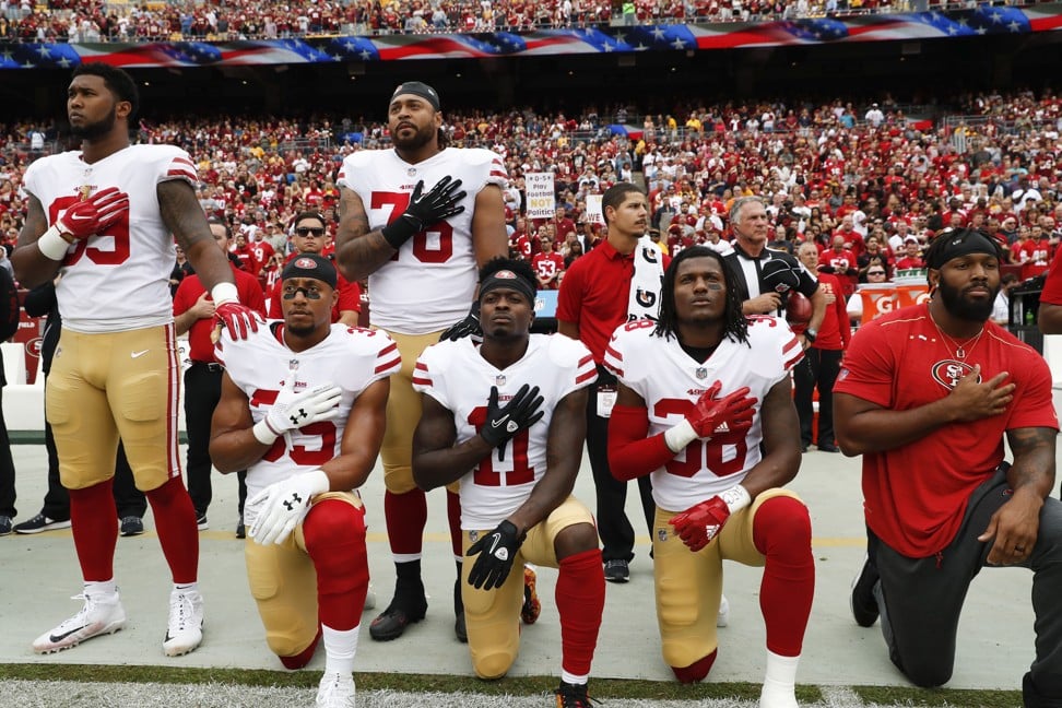 Members of the San Francisco 49ers kneel and stand during the playing of the national anthem before an NFL game against the Washington Redskins. Photo: AP