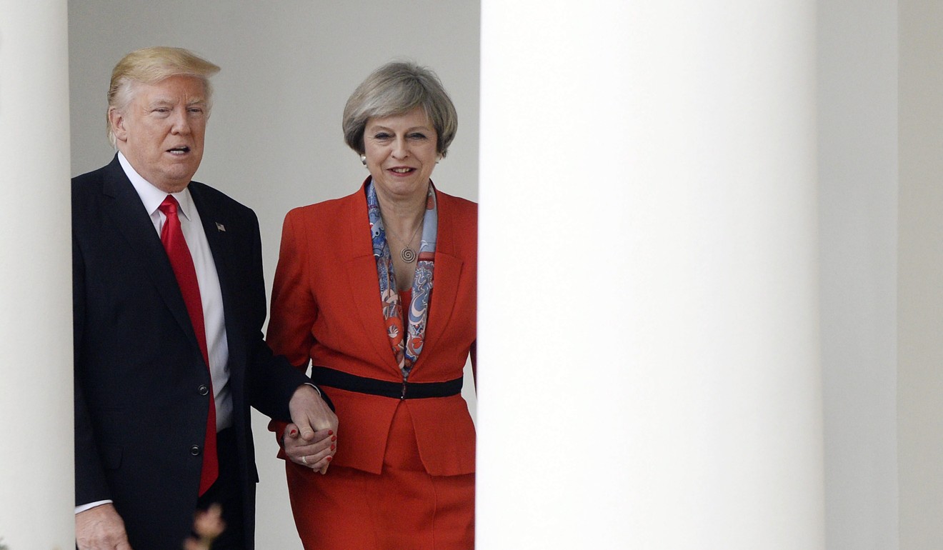 Trump holds hands with Theresa May at the White House in January 2017. Photo: EPA