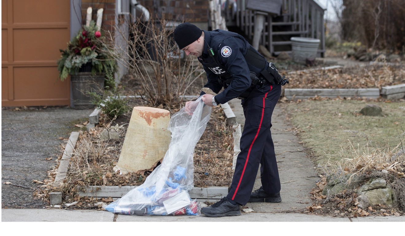 A police officer investigates on Monday outside a house on Mallory Crescent in Toronto, where Bruce McArthur did landscape work. Photo: AP