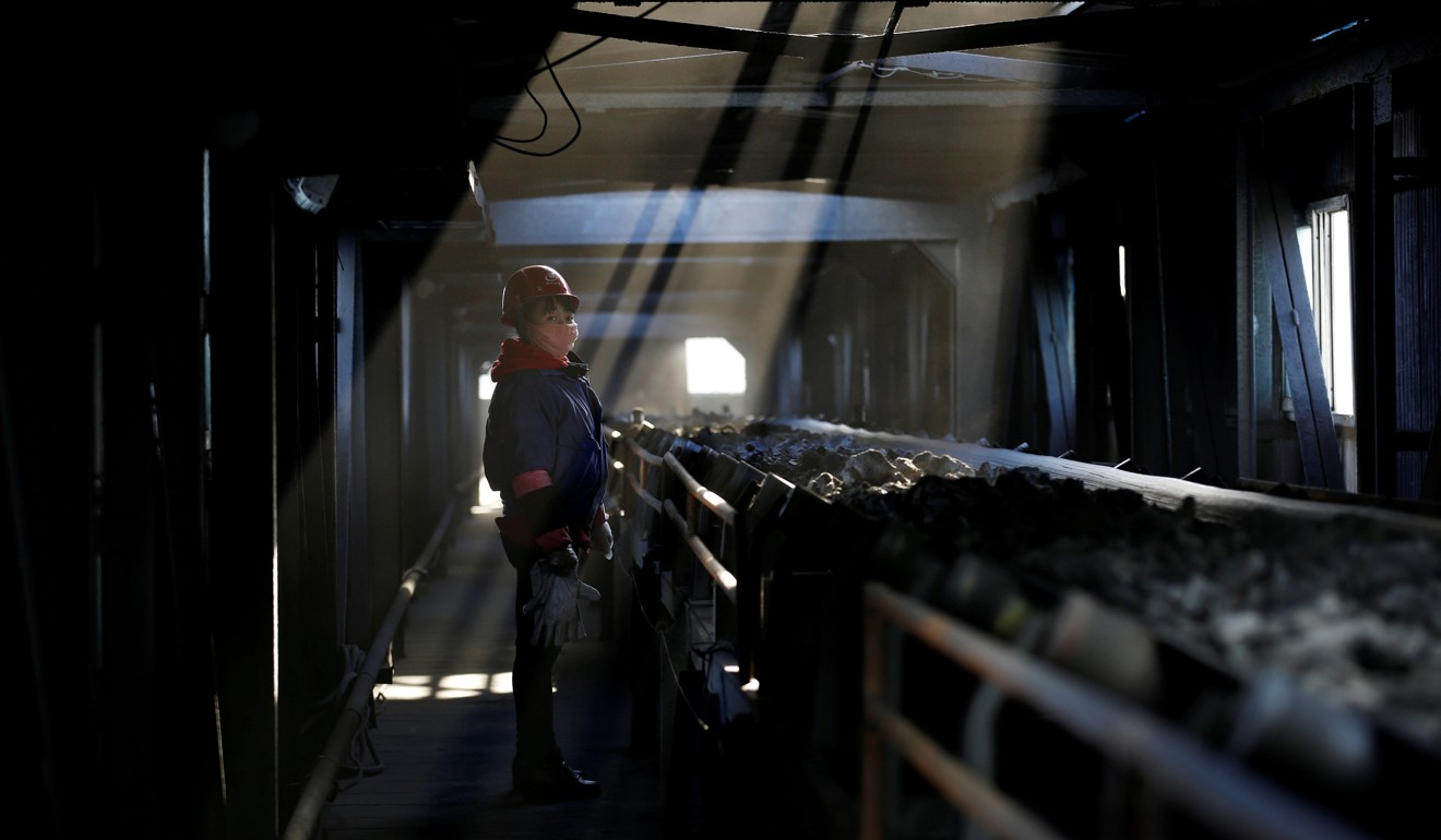 A worker inspects a conveyor belt carrying coal at a coal coking plant in Yuncheng, Shanxi. Thousands of factories must now use rail to ship cargo rather than roads. Photo: Reuters