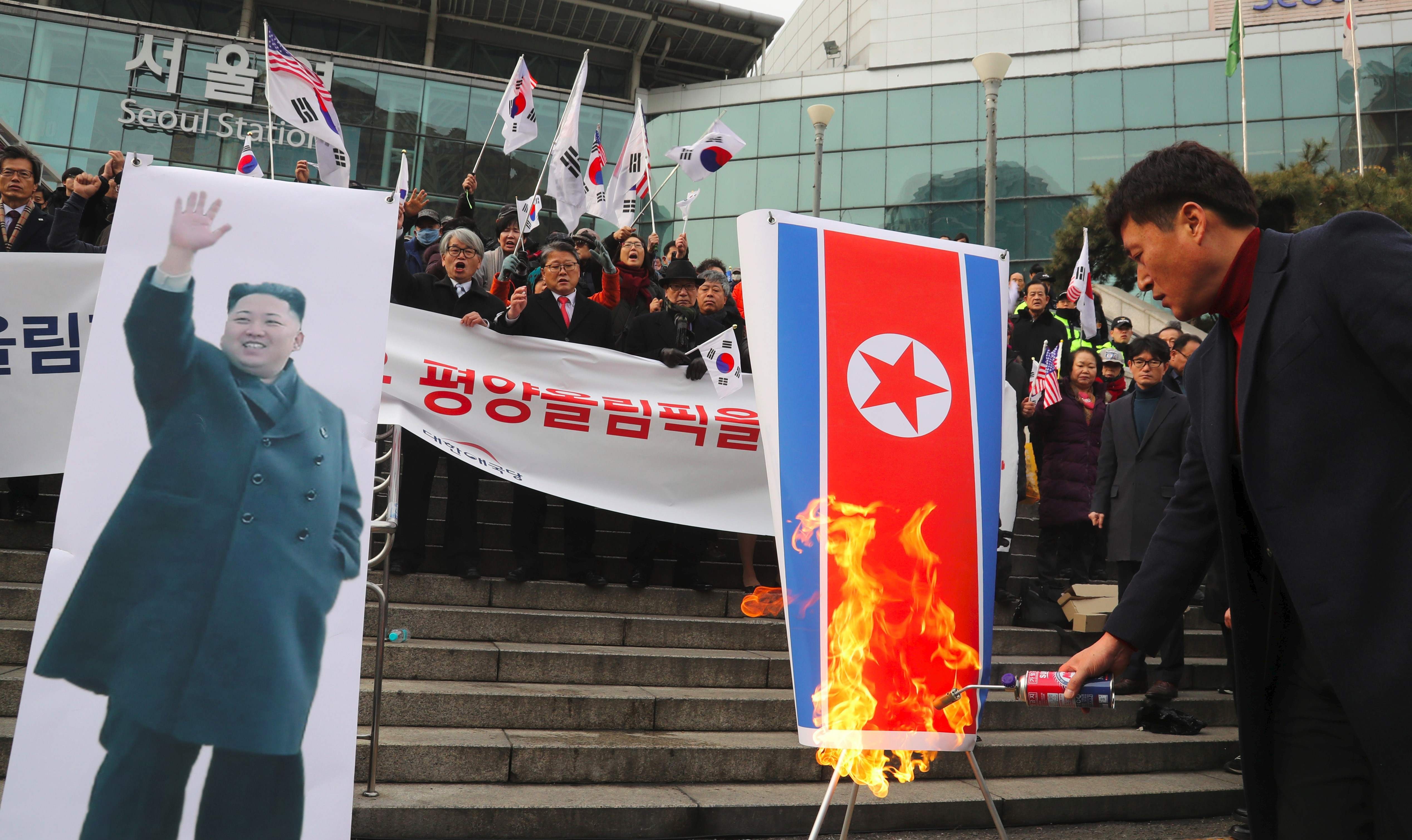 South Korean protesters burn a North Korean flag and a picture of North Korean leader Kim Jong-un during an anti-North Korea rally outside Seoul Station on January 22 as a North Korean delegation arrives. Photo: AFP/Yonhap