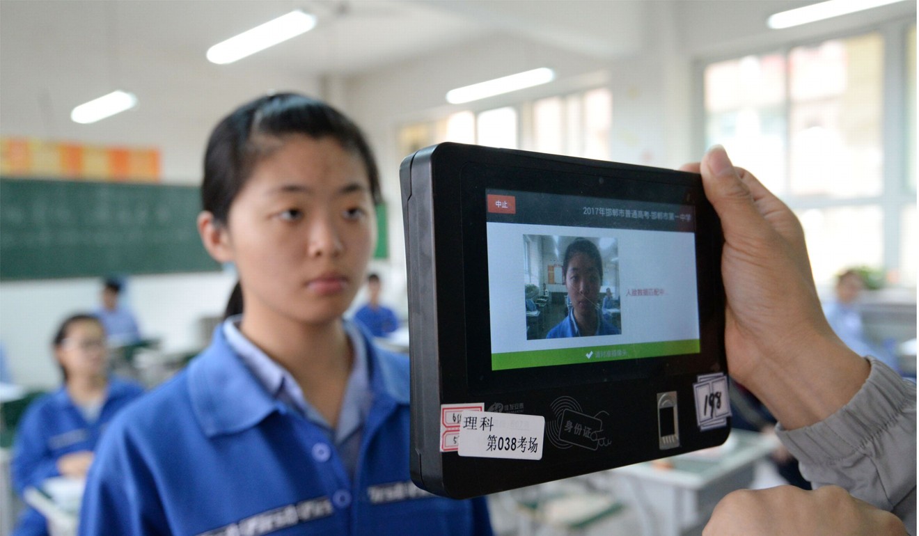 A teacher uses a machine which employs both fingerprint and facial recognition technology to check the identification of a student before a simulated college entrance exam in Handan in China's northern Hebei province. Photo: AFP