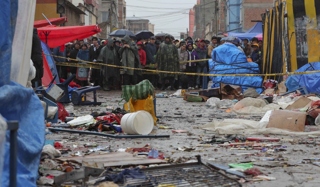 Locals watch from behind of a barricade at the scene of an explosion in the city of Oruro. Photo: EPA