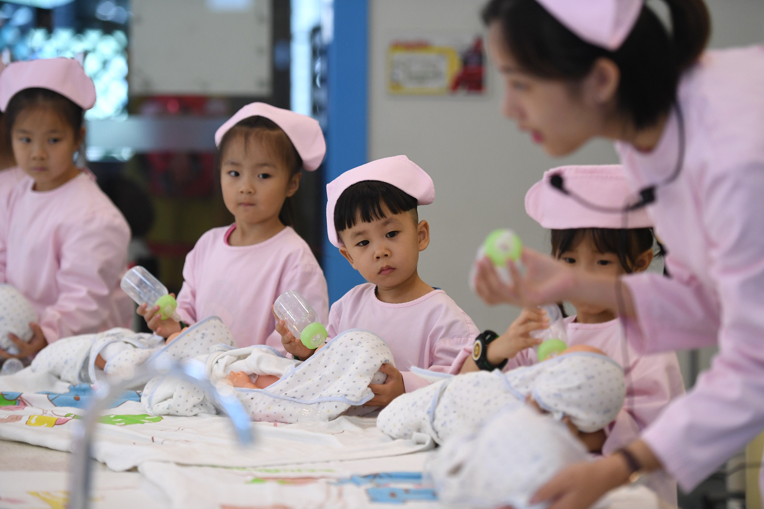 Children practise feeding babies in Hangzhou in 2017. China’s move to a two-child policy in 2015 has not dramatically increased the birth rate. Photo: Xinhua