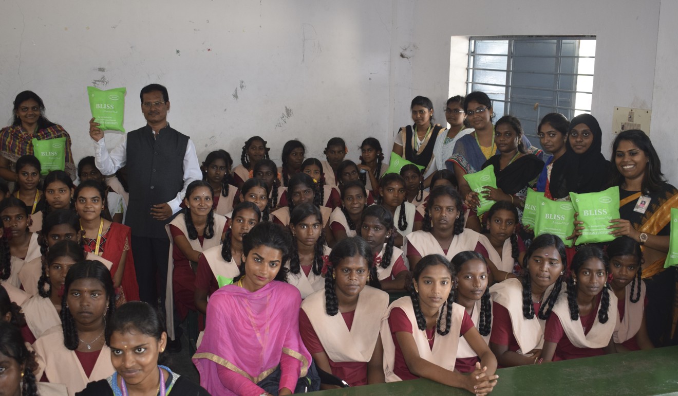 Muruganantham displays the new sanitary pads to village women.