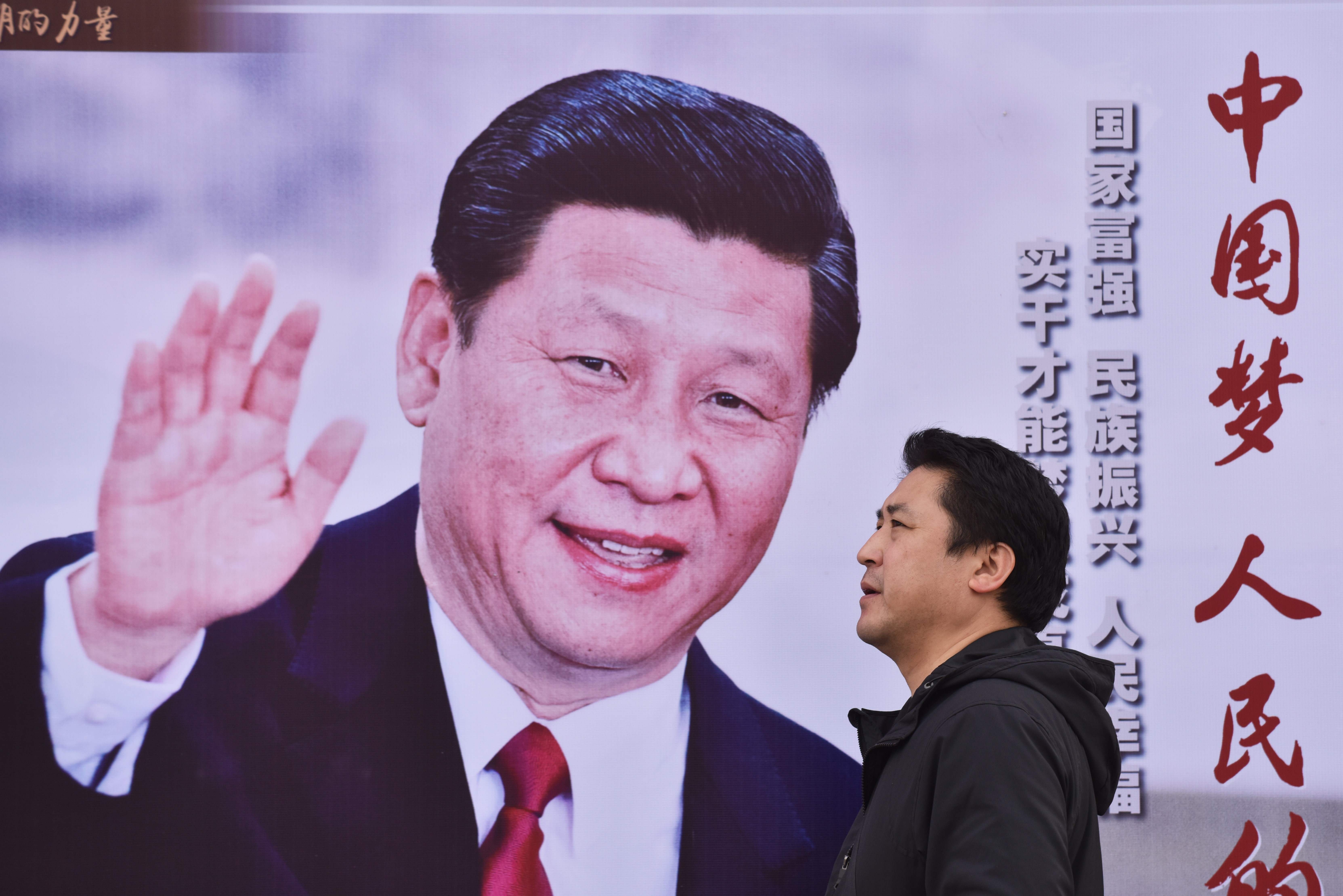 A man walks past a poster of Chinese President Xi Jinping with the slogan “Chinese Dream, People’s Dream” in Beijing on October 16, 2017. Photo: AFP