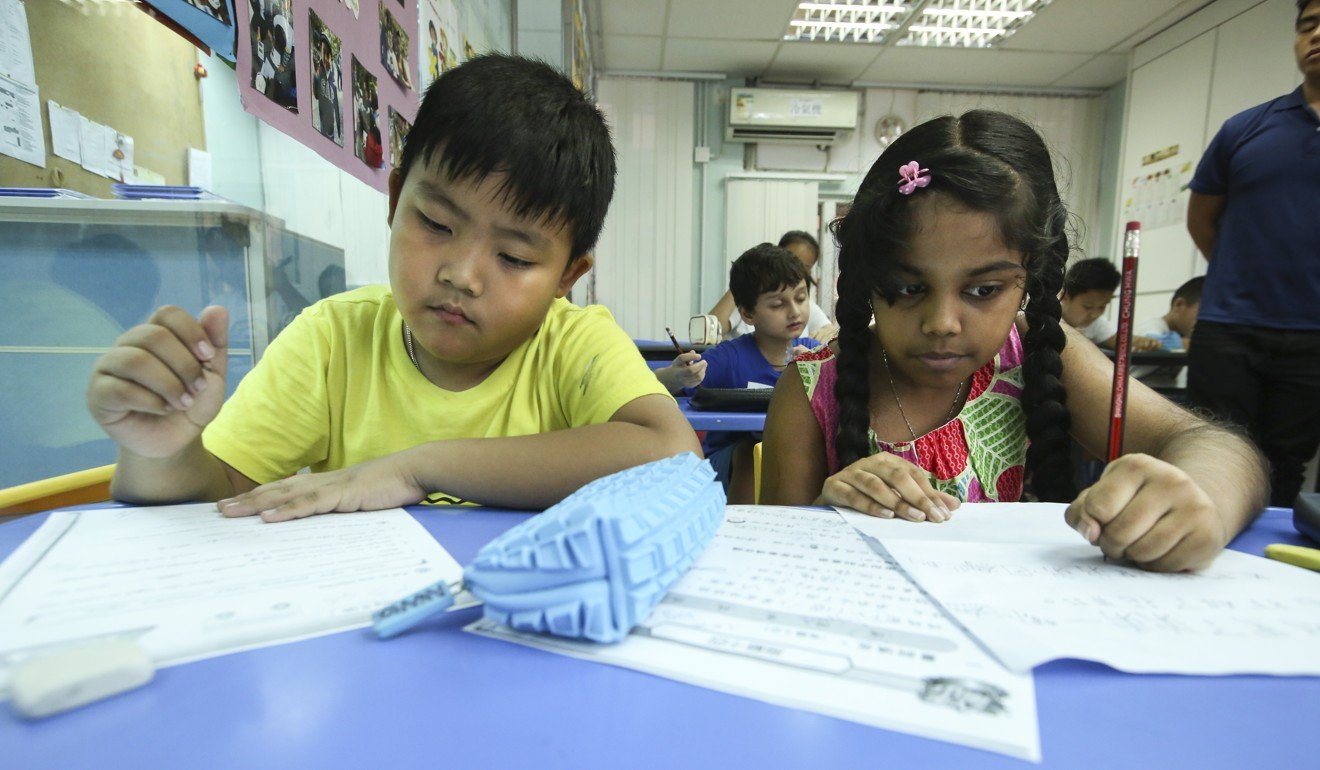 Two students get help with their homework at an after-school centre in Jordan, Hong Kong. Children from Hong Kong’s ethnic minority community struggle to master traditional Chinese characters. Photo: Edmond So