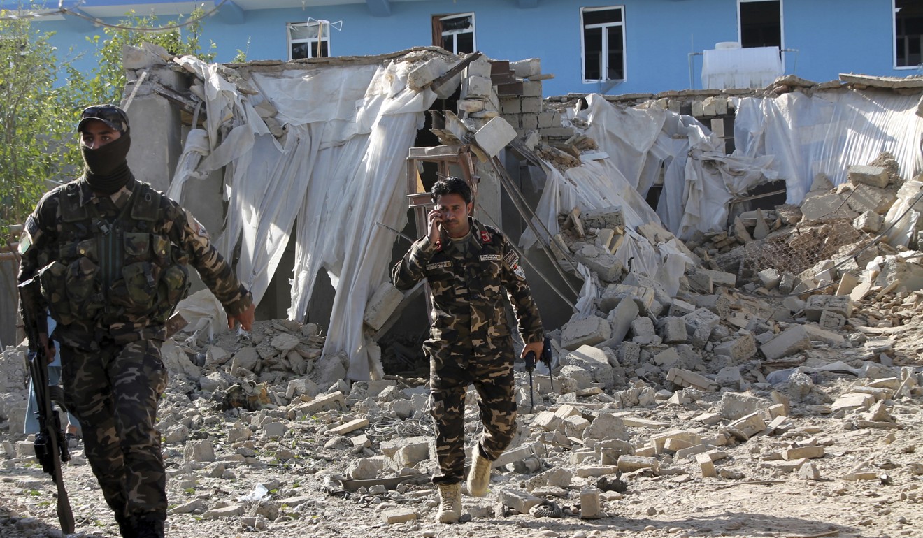 Security forces inspect an explosion site in Lashkar Gah, in the southern Helmand province. Photo: AP