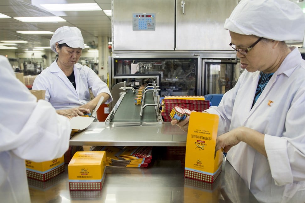 Workers pack Tiger Balm at the Haw Par Corporation's Tiger Balm factory in Singapore. Photo: Christopher DeWolf