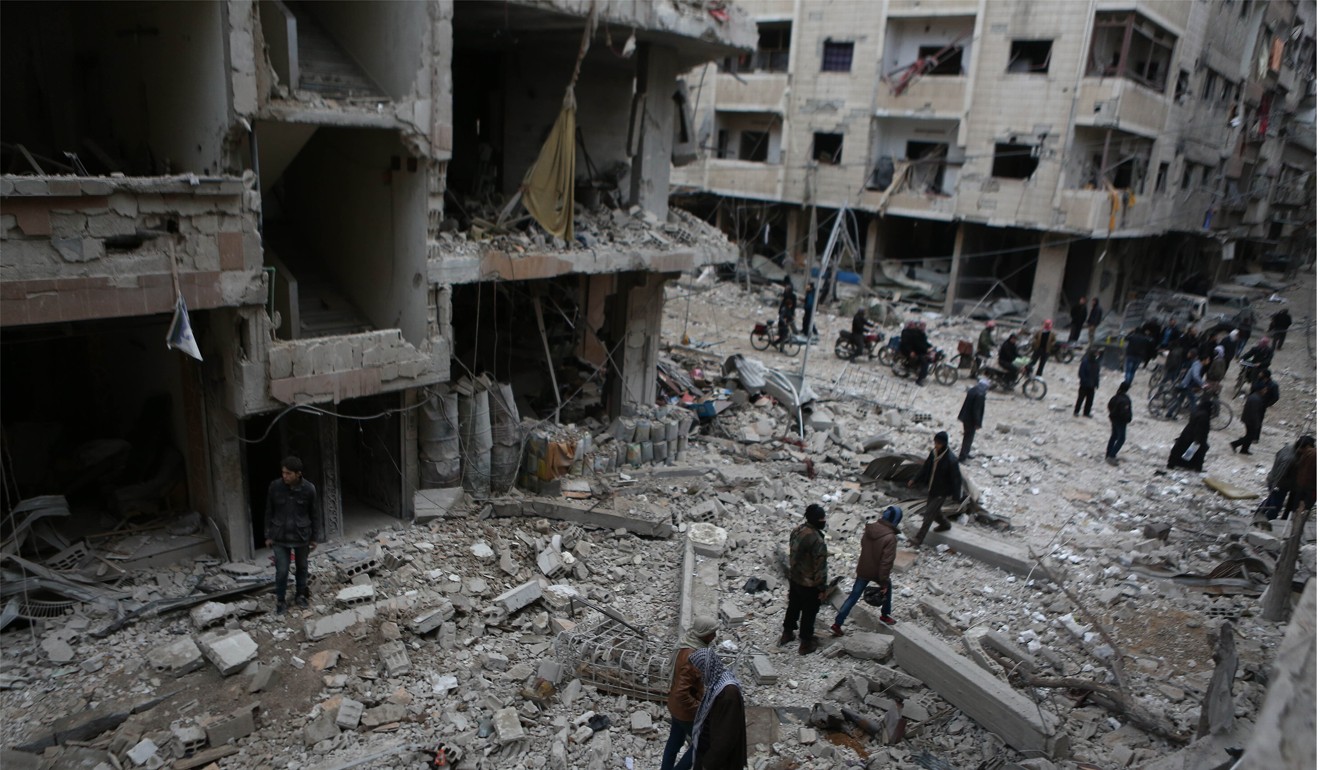 Syrians inspect the debris of buildings destroyed by Syrian forces' missile strikes in Eastern Ghouta on February 22. Photo: DPA/Abaca Press/TNS