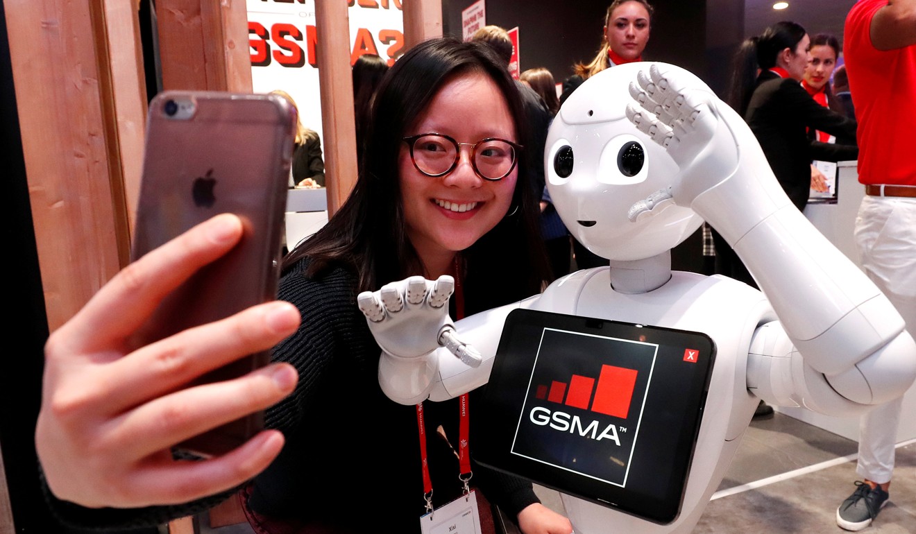 A visitor takes a selfie with the Robot Assistant Pepper, from SoftBank Robotics, during the Mobile World Congress in Barcelona, Spain, on Wednesday. Photo: Reuters