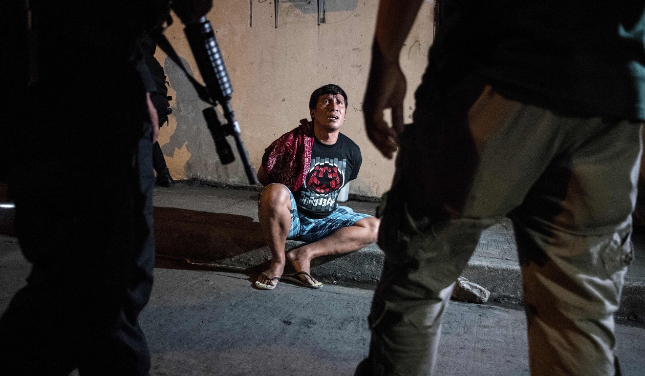 Philippine Drug Enforcement Agency agents and police arrest an alleged drug dealer during a raid south of Manila. More than 100 drug suspects have been killed since President Duterte ordered police to rejoin his war on drugs. Photo: AFP