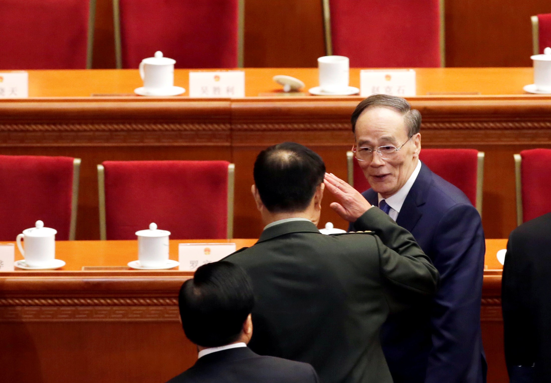 General Fan Changlong salutes former anti-graft tsar Wang Qishan as he leaves after the opening session of the National People's Congress at the Great Hall of the People in Beijing on Monday. Photo: Reuters