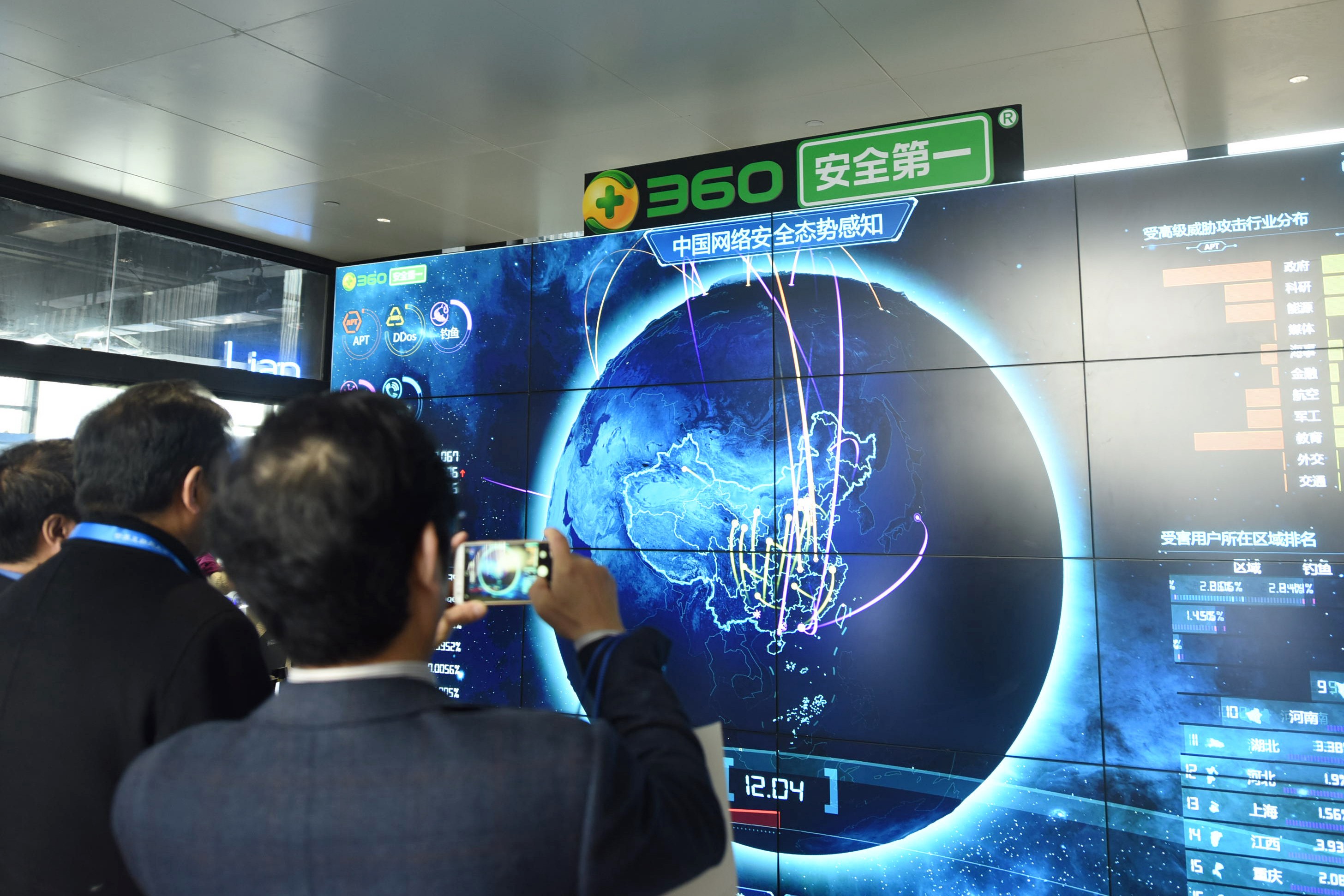 A man takes pictures of internet security data displayed on a screen at the Qihoo booth during the World Internet Conference in Wuzhen, China, last December. Photo: AFP