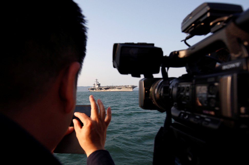A cameraman records the US Navy aircraft carrier, USS Carl Vinson, at a port in Da Nang, Vietnam, on Monday. Photo: Reuters