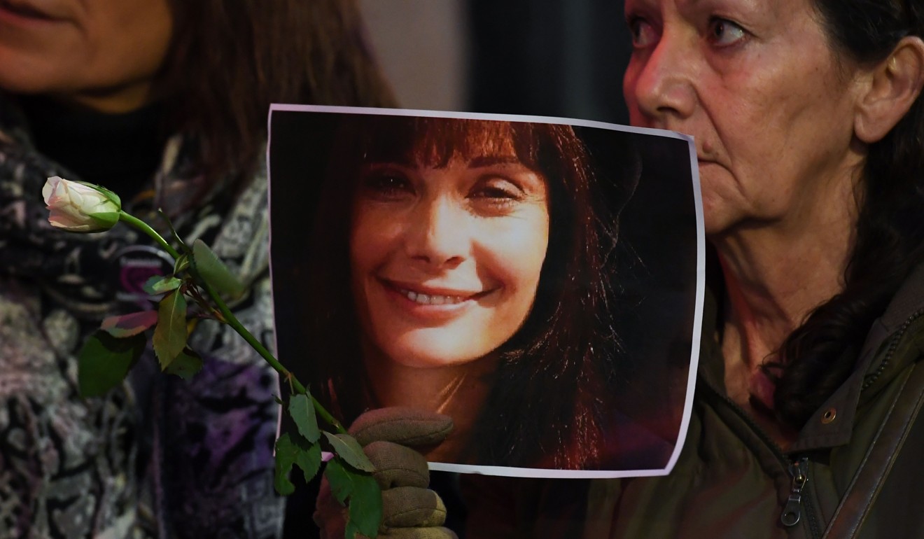 A protester holds a photo of late French actress Marie Trintignant, beaten to death by singer Bertrand Cantat in 2003, outside a concert by Cantat in Montpellier on Monday. Photo: Agence France-Presse