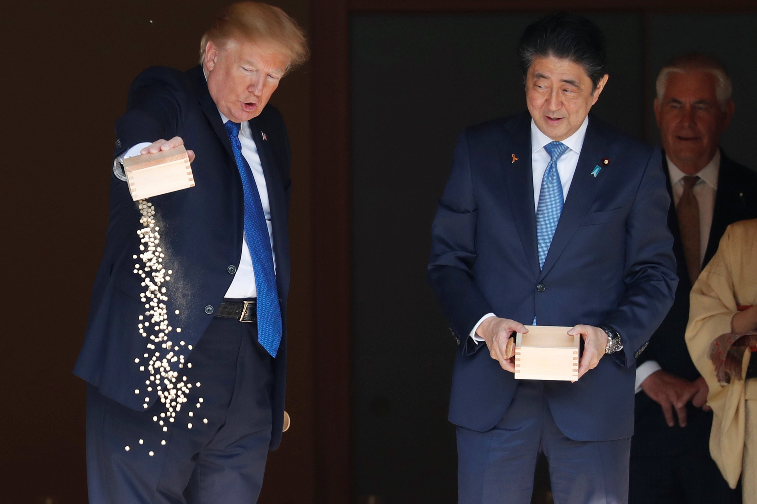 US President Donald Trump and Japan's Prime Minister Shinzo Abe take part in a ceremony to feed carp before their talks in Tokyo on November 6, 2017. Photo: Reuters