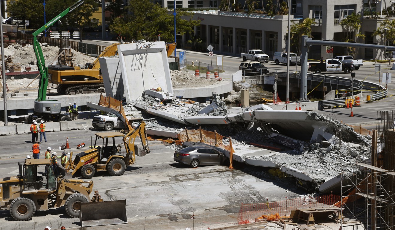 Crushed cars lie under a section of a collapsed pedestrian bridge near Florida International University in the Miami area on Friday. Photo: AP