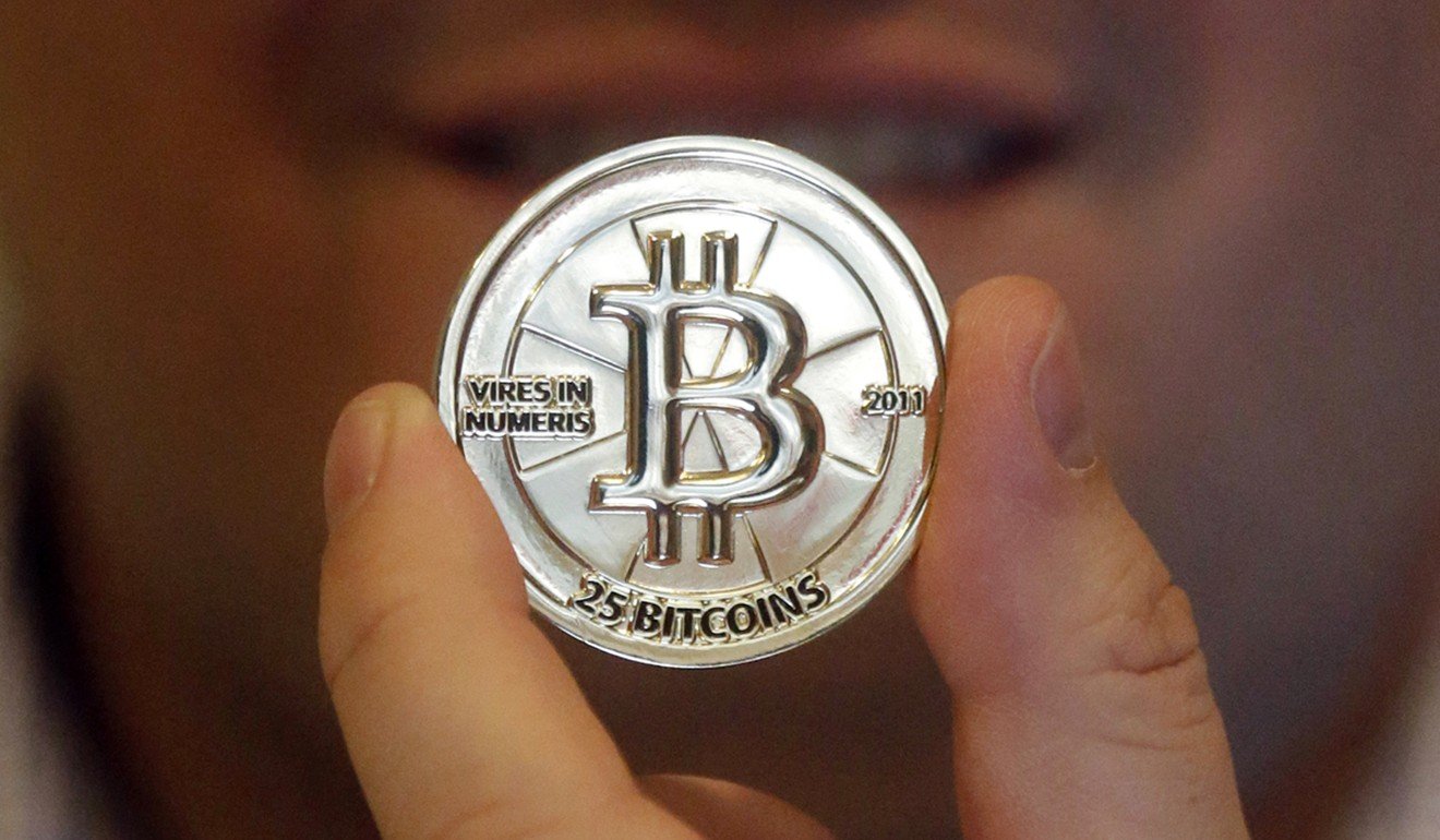 In this April 3, 2013 photo, Mike Caldwell, a 35-year-old software engineer, holds a 25 Bitcoin token at his shop in Sandy, Utah. Bitcoin and other crypto assets are not yet a threat to the financial statement, a report by the Financial Stability Board to the G20 said on March 18, 2018. Photo: AP
