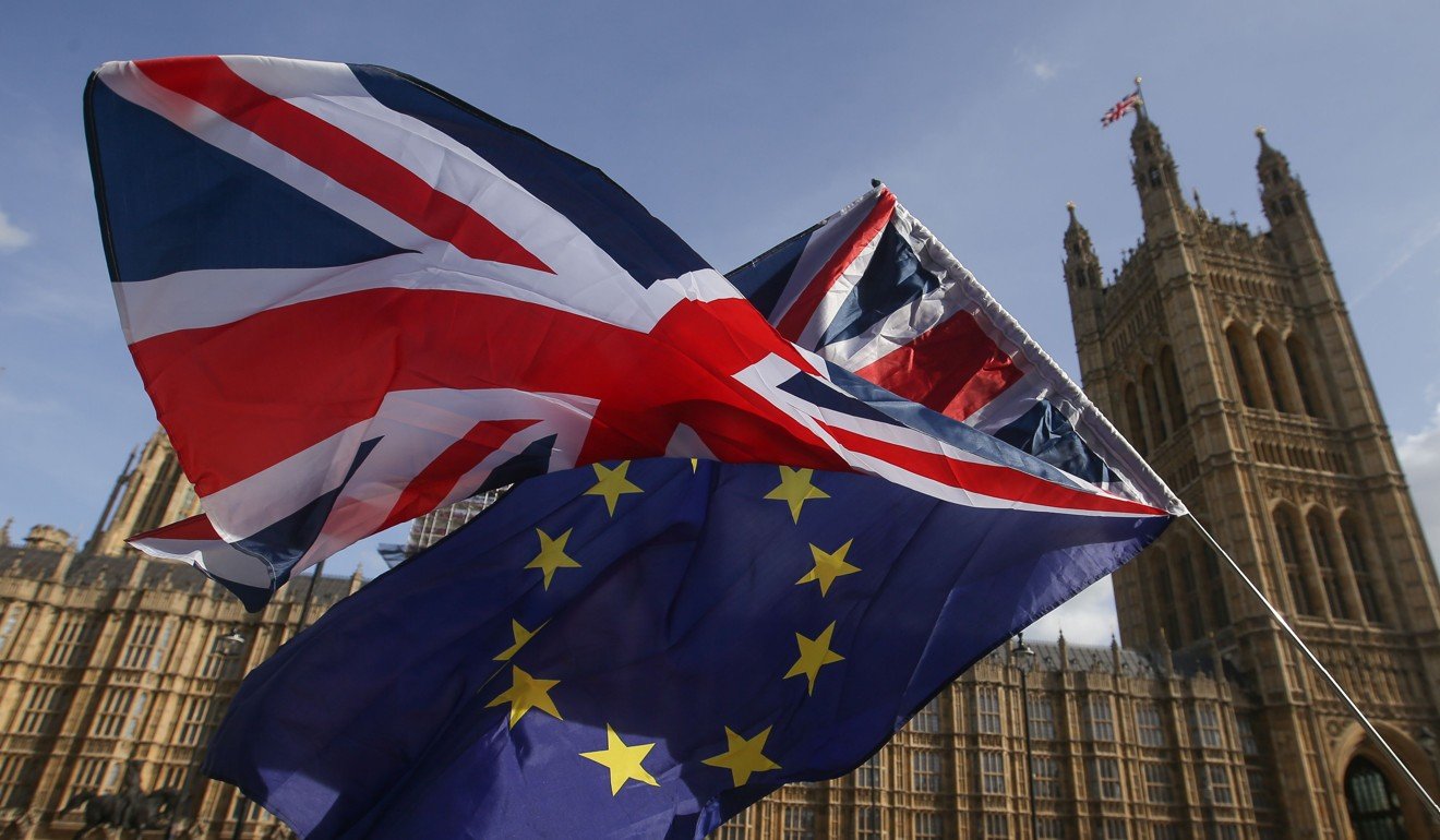 Demonstrators fly a Union flag and an EU flag outside the Houses of Parliament in Westminster, London in October last year. Photo: AFP 