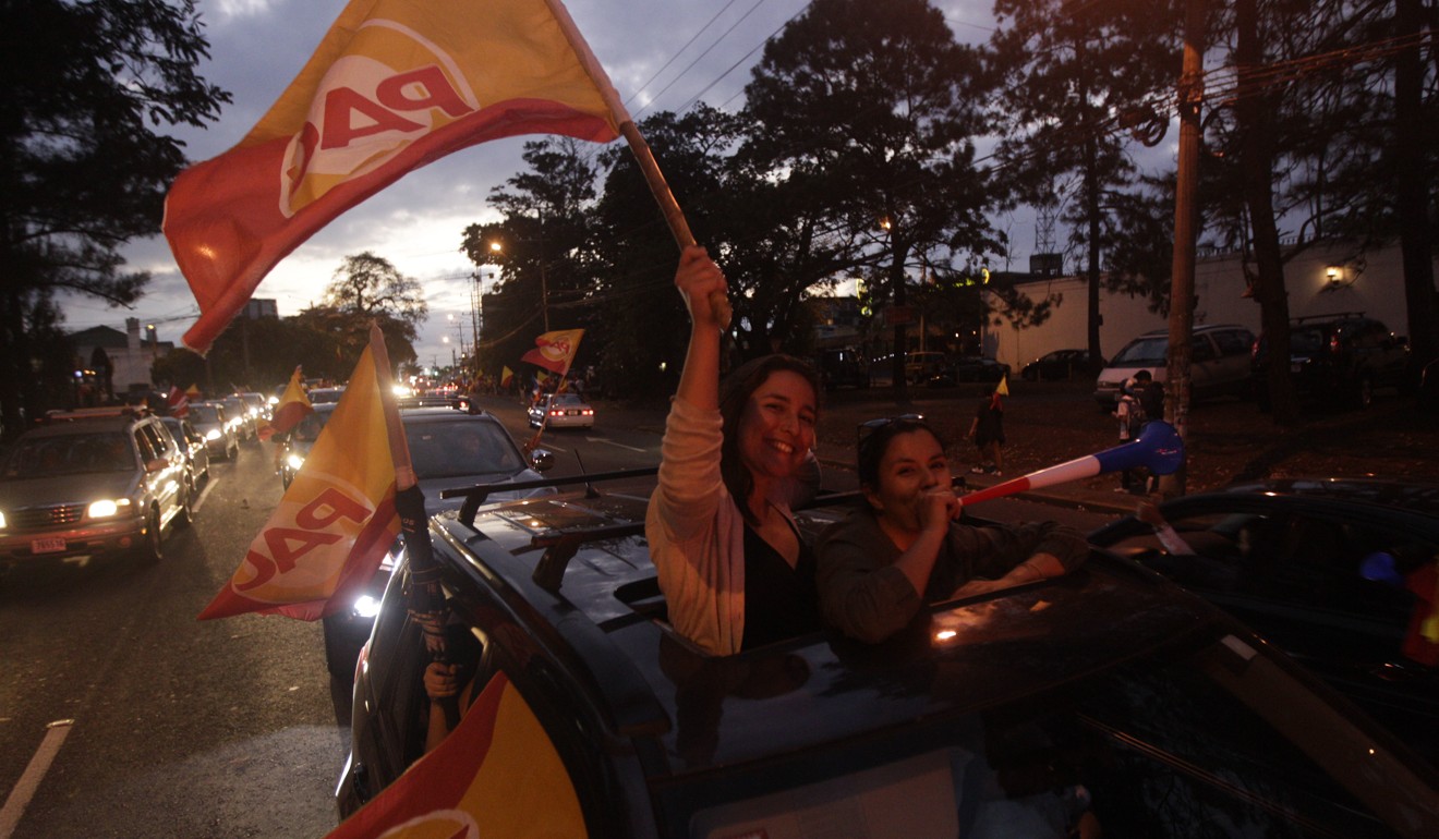 Supporters of presidential candidate Carlos Alvarado, of the Citizen Action Party, wave party flags from a car after polls closed in San Jose on Sunday. Photo: AP