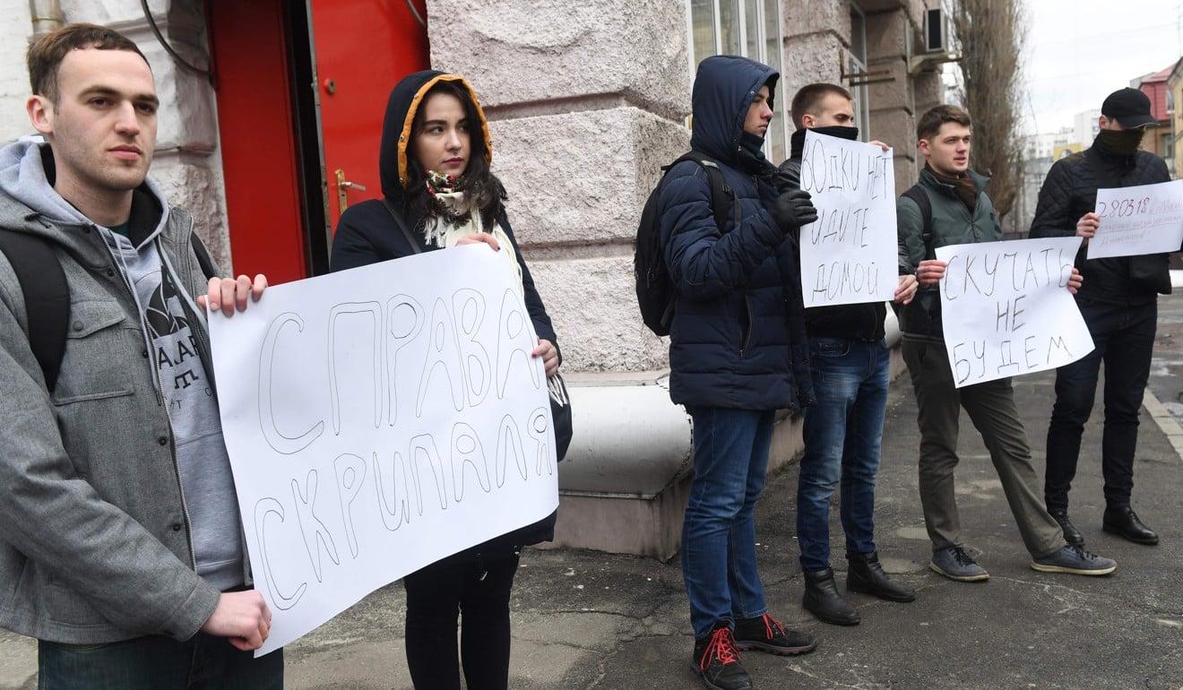 Activists hold placards reading ‘There is no vodka, go home’ and ‘We will not miss you’ during their waiting for the Russian diplomats leaving the Russian embassy in Kiev, Ukraine. Photo: AFP