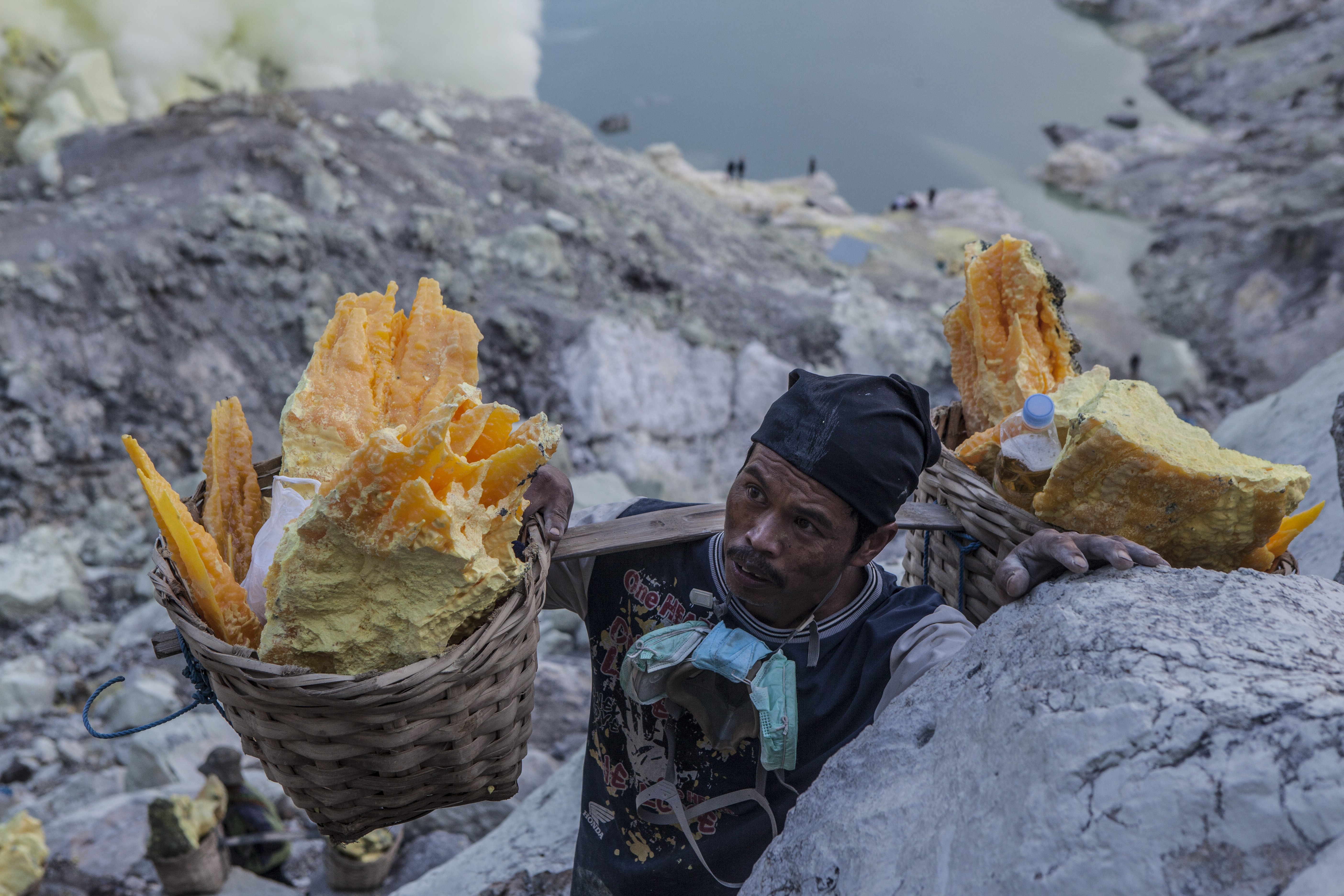 Miner carrying baskets of sulphur in Kawah Ijen, East Java, Indonesia. Photo: Agoes Rudianto
